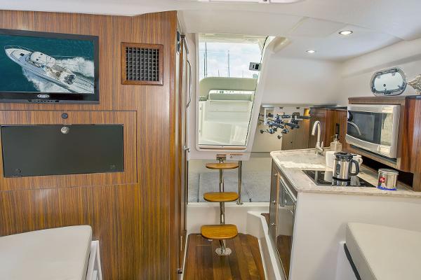 Manufacturer Provided Image: Interior of 2021 Pursuit OS 325 Offshore boat with kitchen and seating area.