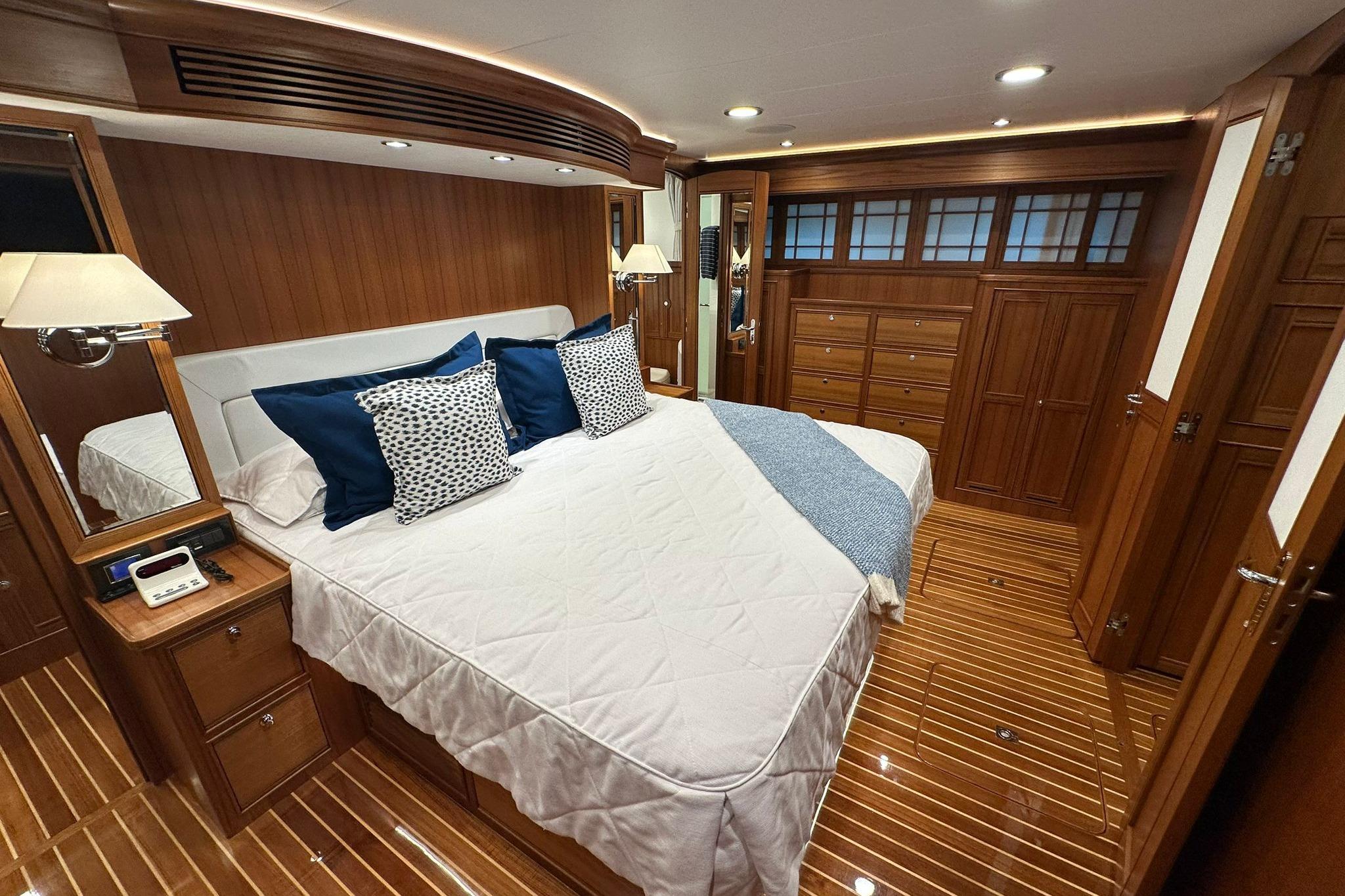 Luxurious cabin interior of 2023 Marlow Explorer 66E-CB yacht with elegant wood finish.