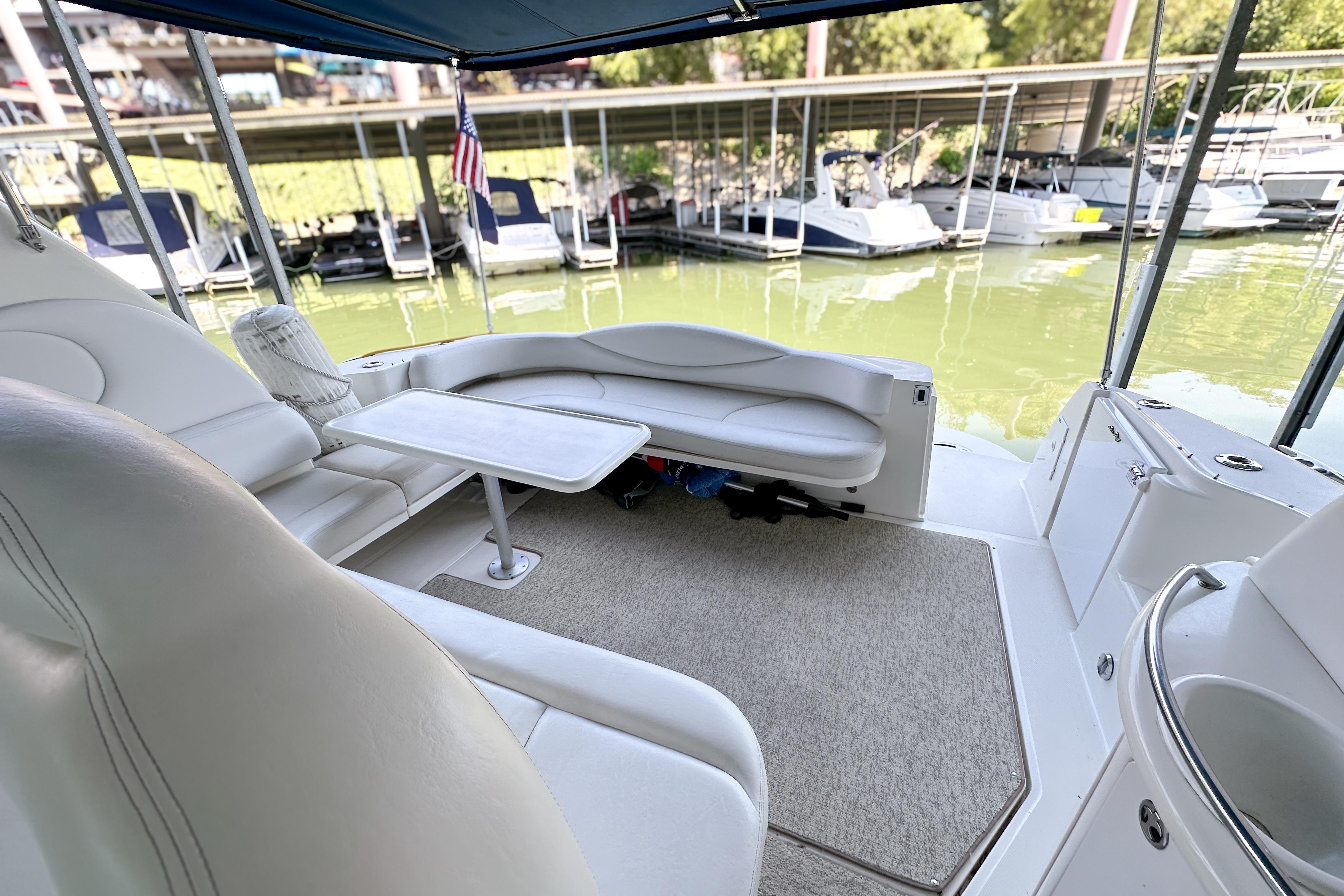 Interior of 2001 Sea Ray 410 Sundancer yacht with seating and table, docked at marina.