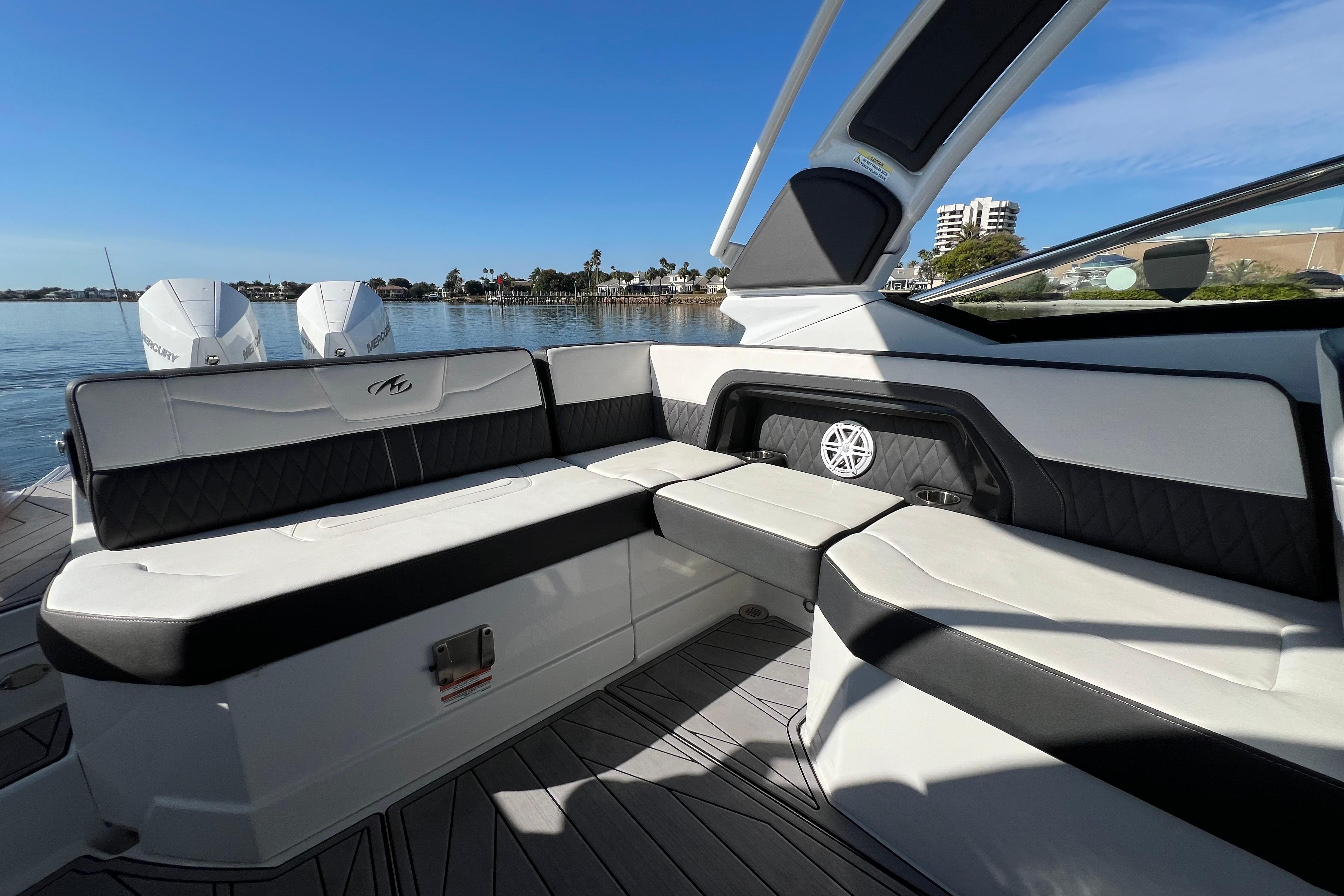 2023 Monterey 305SS Super Sport boat interior with luxurious seating and scenic waterfront view.