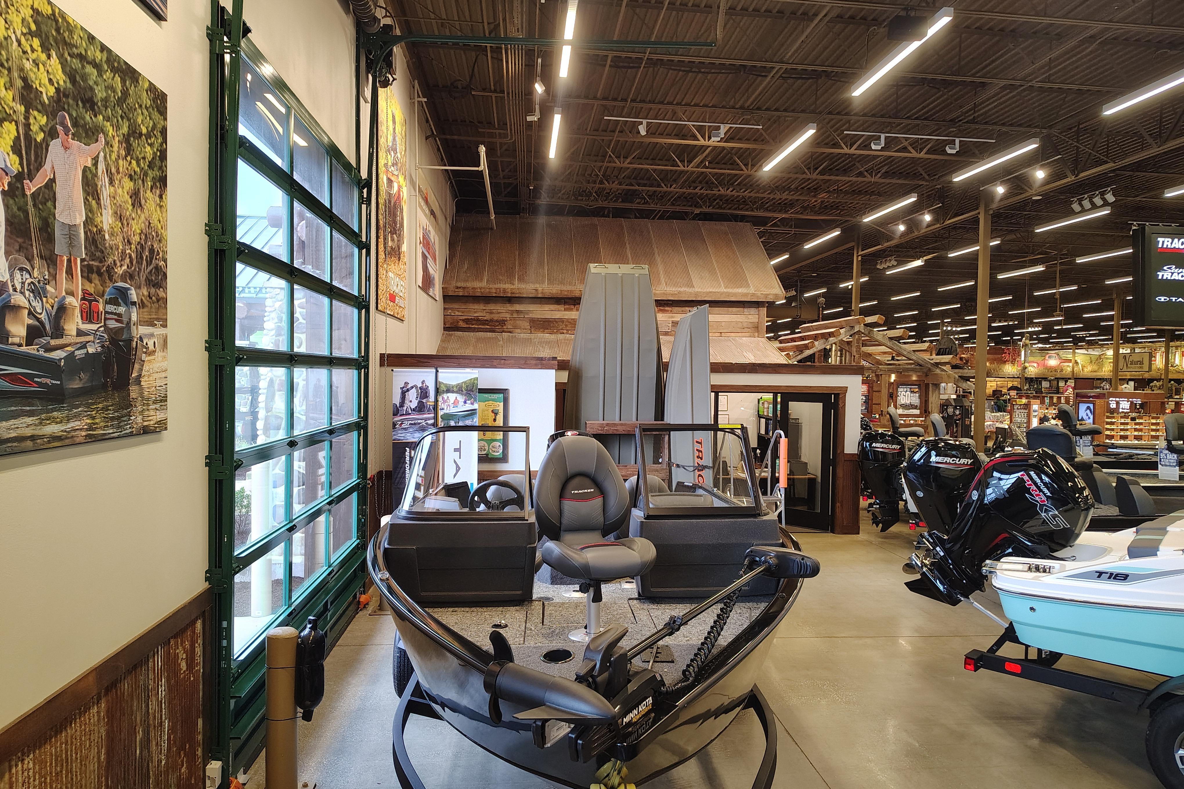2026 Tracker Pro Guide V-175 WT boat displayed in a showroom with fishing gear.