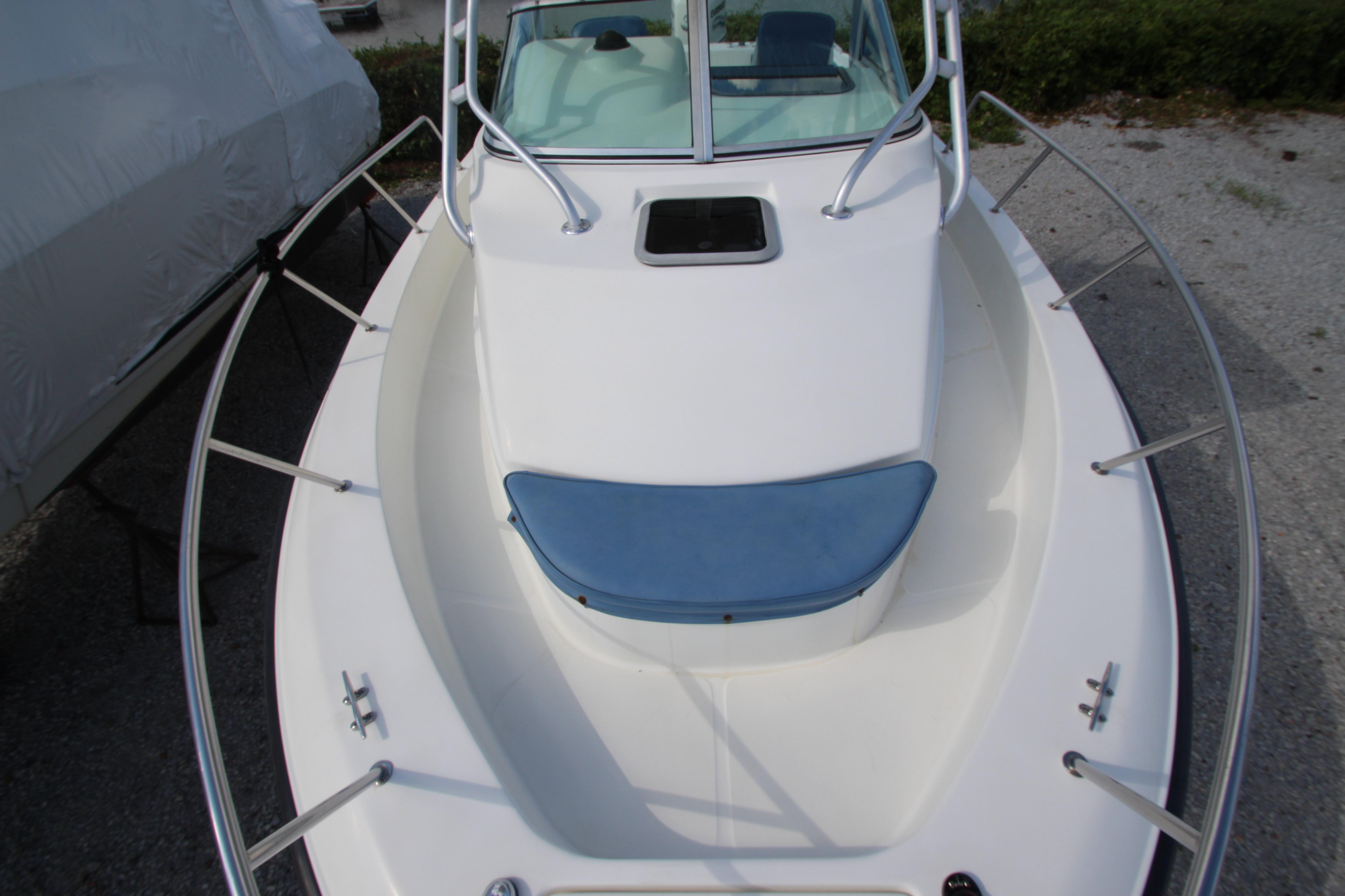 2002 Hydra-Sports 230 WA boat, white deck with blue cushion, docked outdoors.