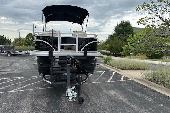 2025 Sun Tracker Sportfish 24 XP3 pontoon boat on trailer in parking lot.