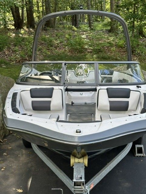 A 2019 Yamaha AR195 boat on a trailer in a wooded area.