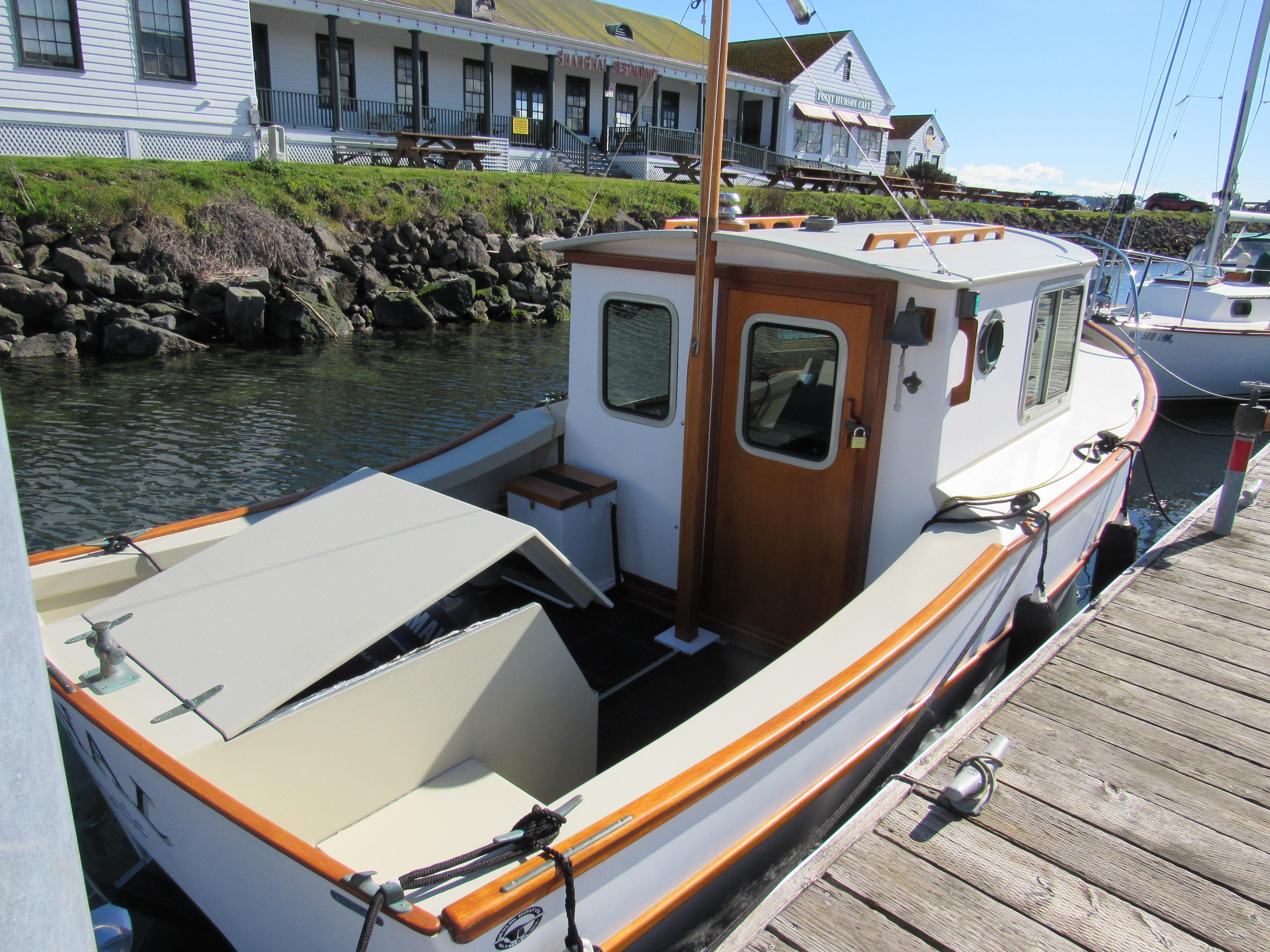 1992 Devlin Surf Scoter boat docked by a wooden pier, with a classic cabin design.