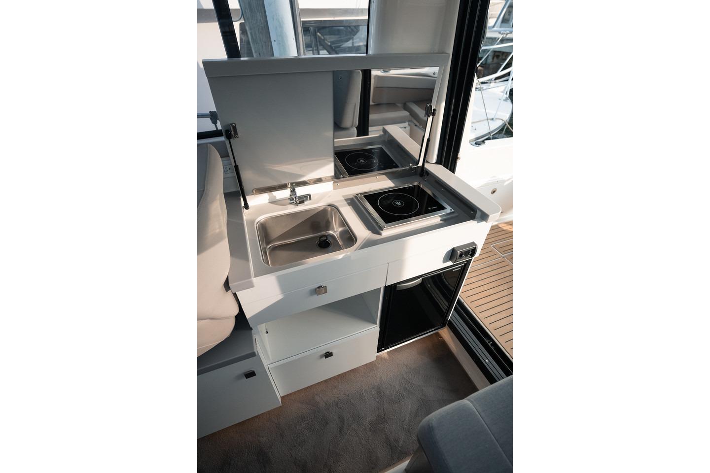 Compact kitchen area in 2026 Trophy T29 Explorer boat with sink and stove.