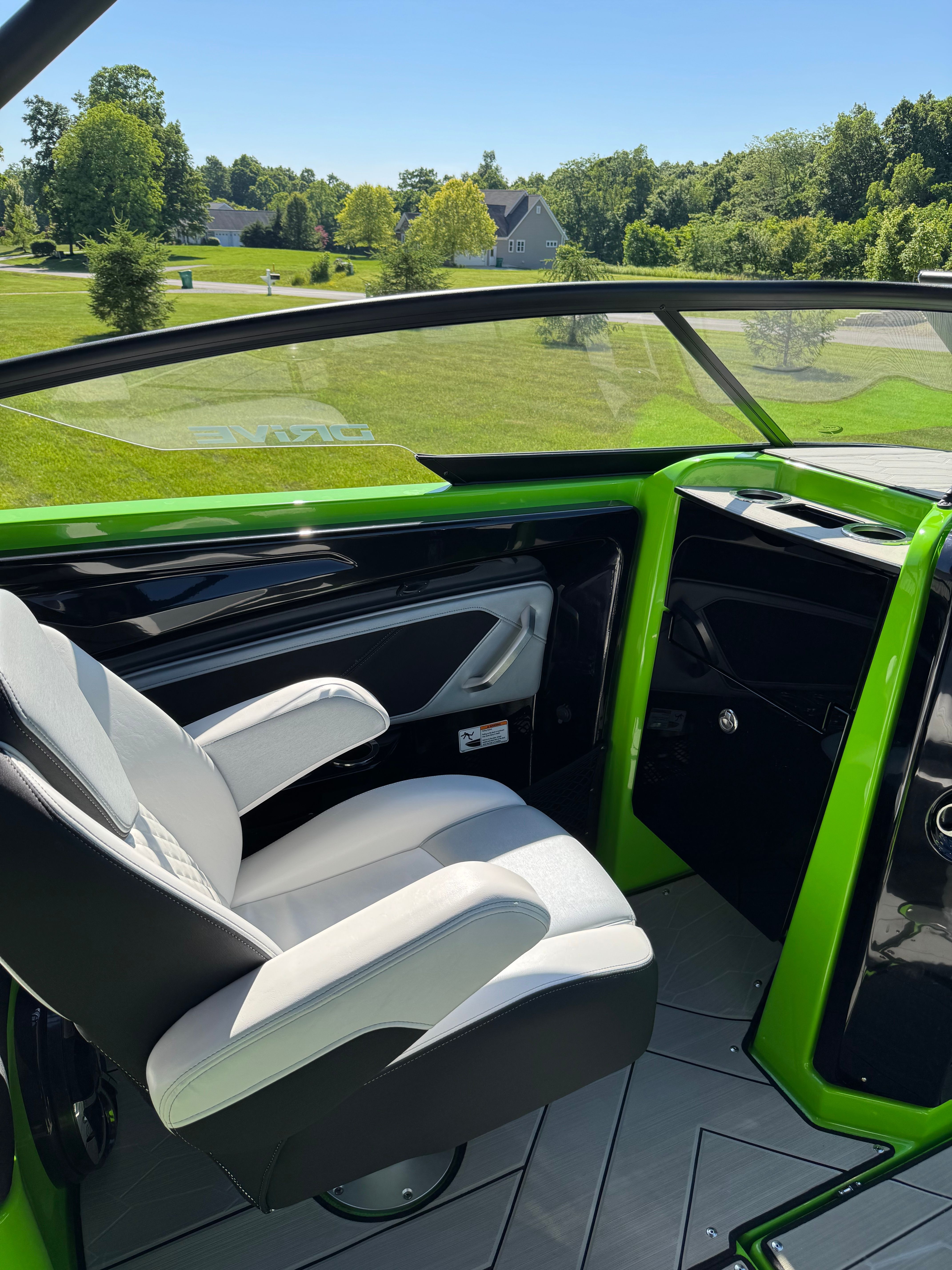 Green boat with a white seat, surrounded by green landscape.