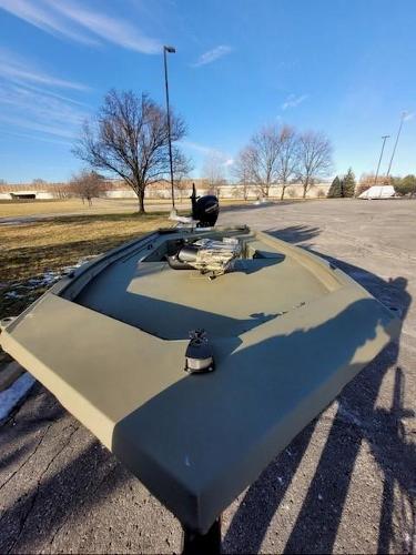 2025 Tracker Grizzly 1654 T Sportsman boat in a parking lot under clear blue sky.