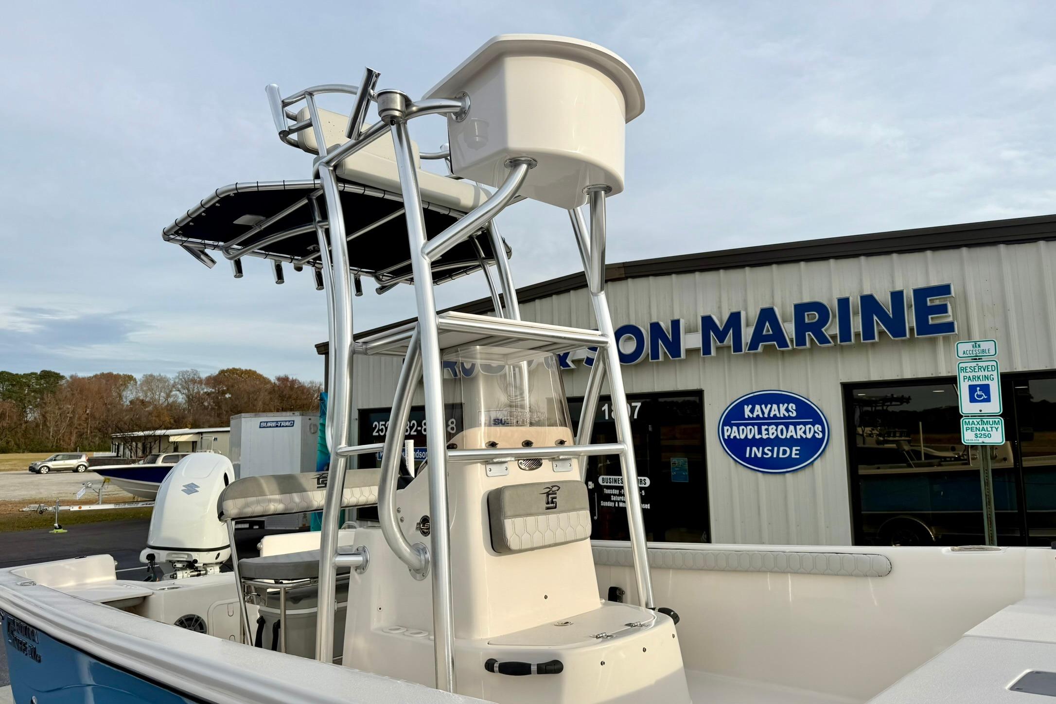 2025 Carolina Skiff 21 LS boat with tower, parked outside a marine store.