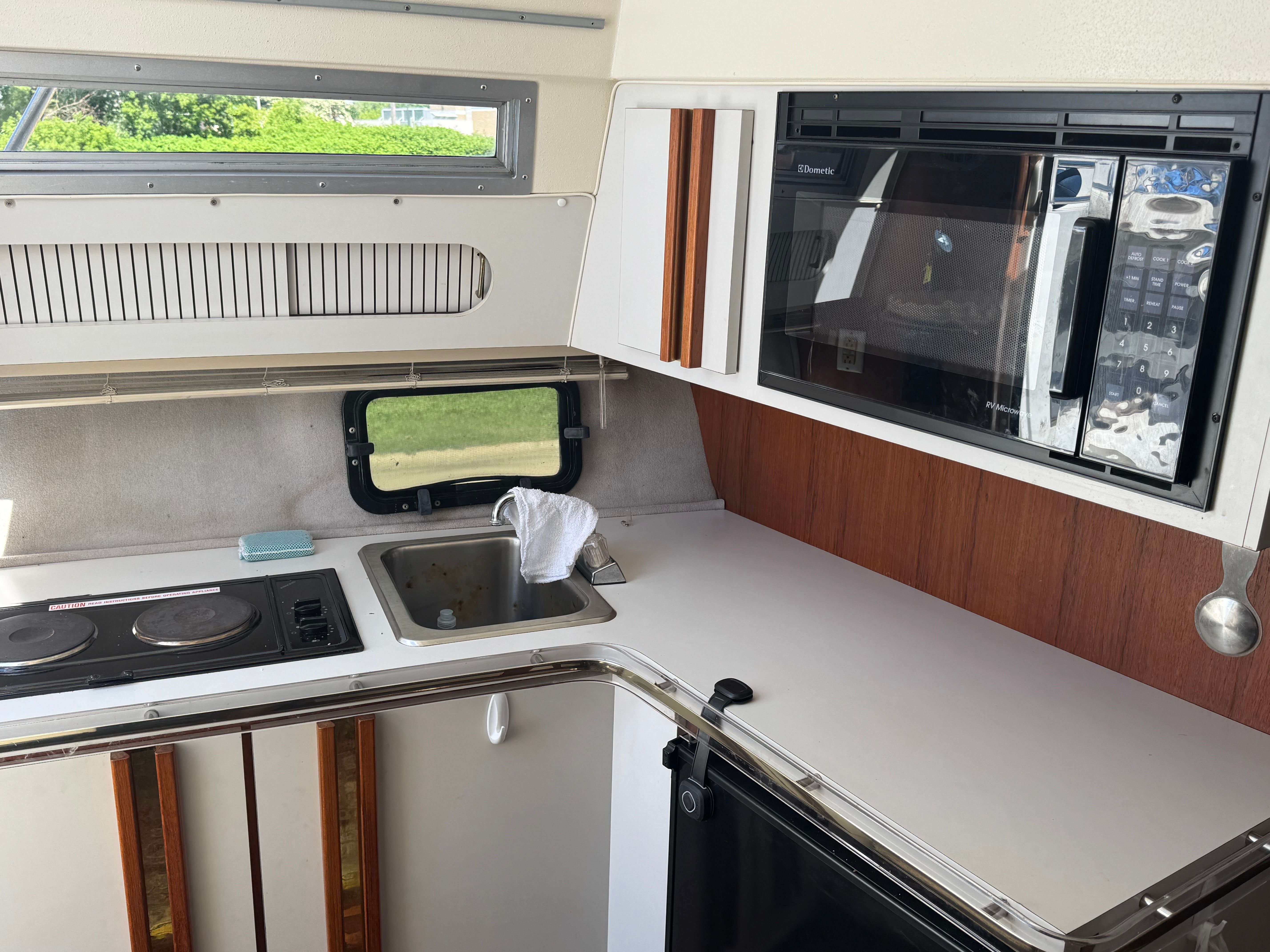The galley of a 1992 Cruisers Yachts Esprit 3370 with stove, sink, and microwave.