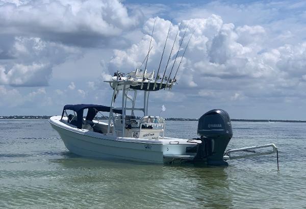 A 2011 Andros 26 Tarpon boat floats in calm water, equipped with fishing rods and an outboard motor.