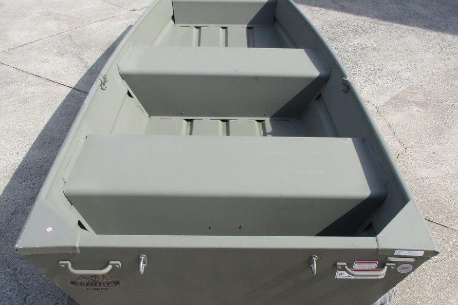 2023 Tracker Grizzly 1236 Jon boat, olive green, on concrete surface.
