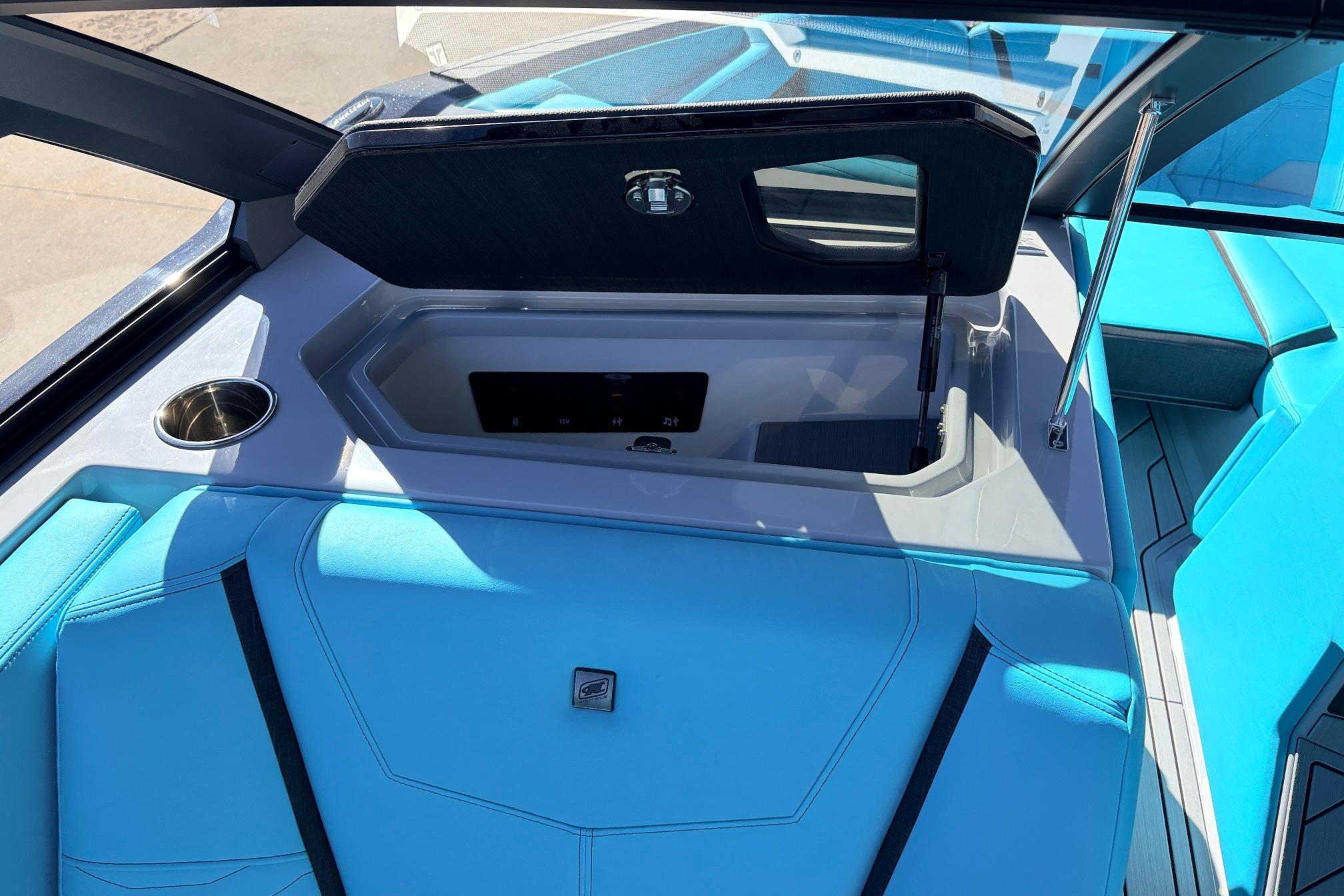 2026 Nautique Super Air Nautique G23 interior with blue seating and storage compartment.