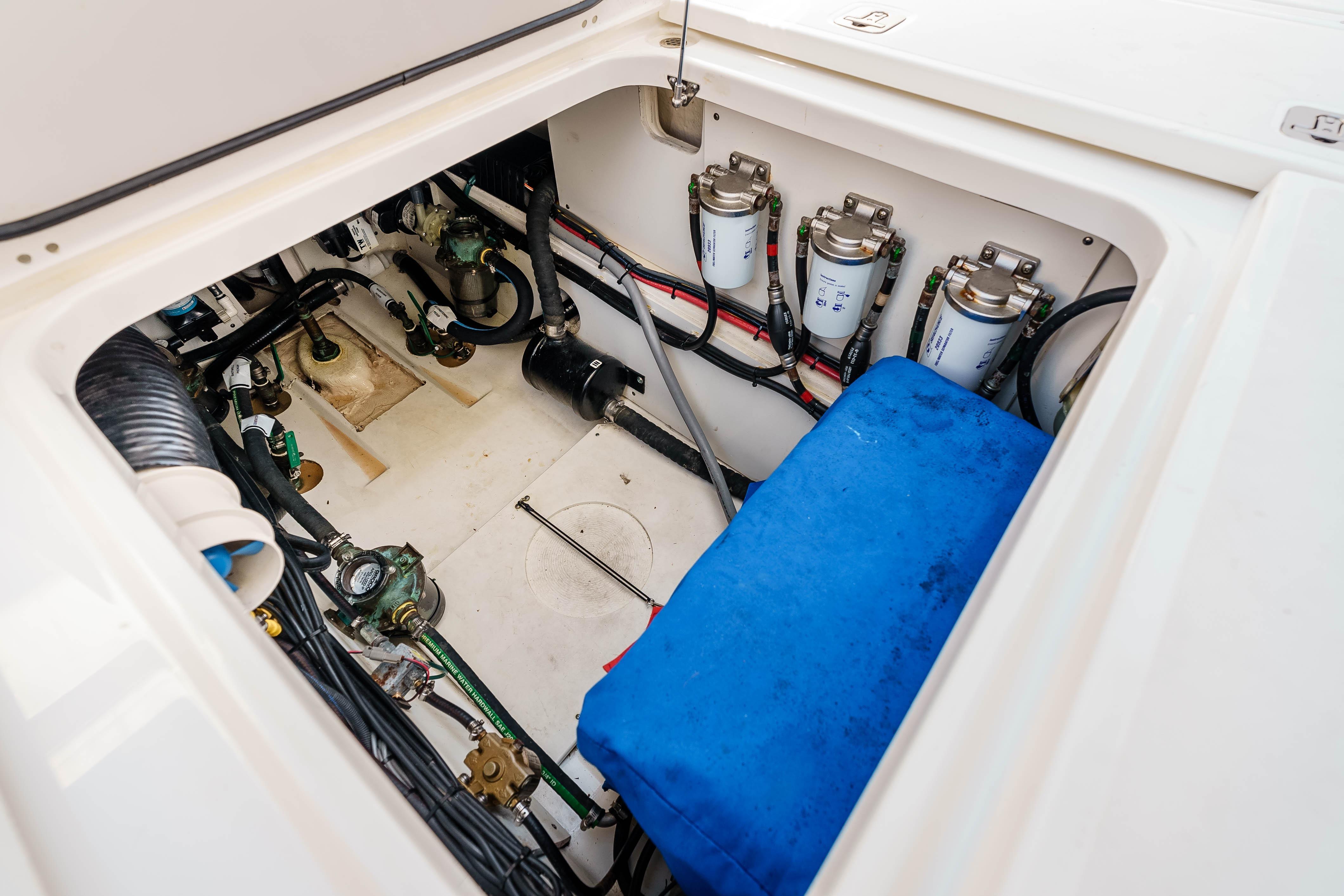 Engine compartment of 2022 Pursuit OS 385 Offshore boat, showcasing filters and wiring.