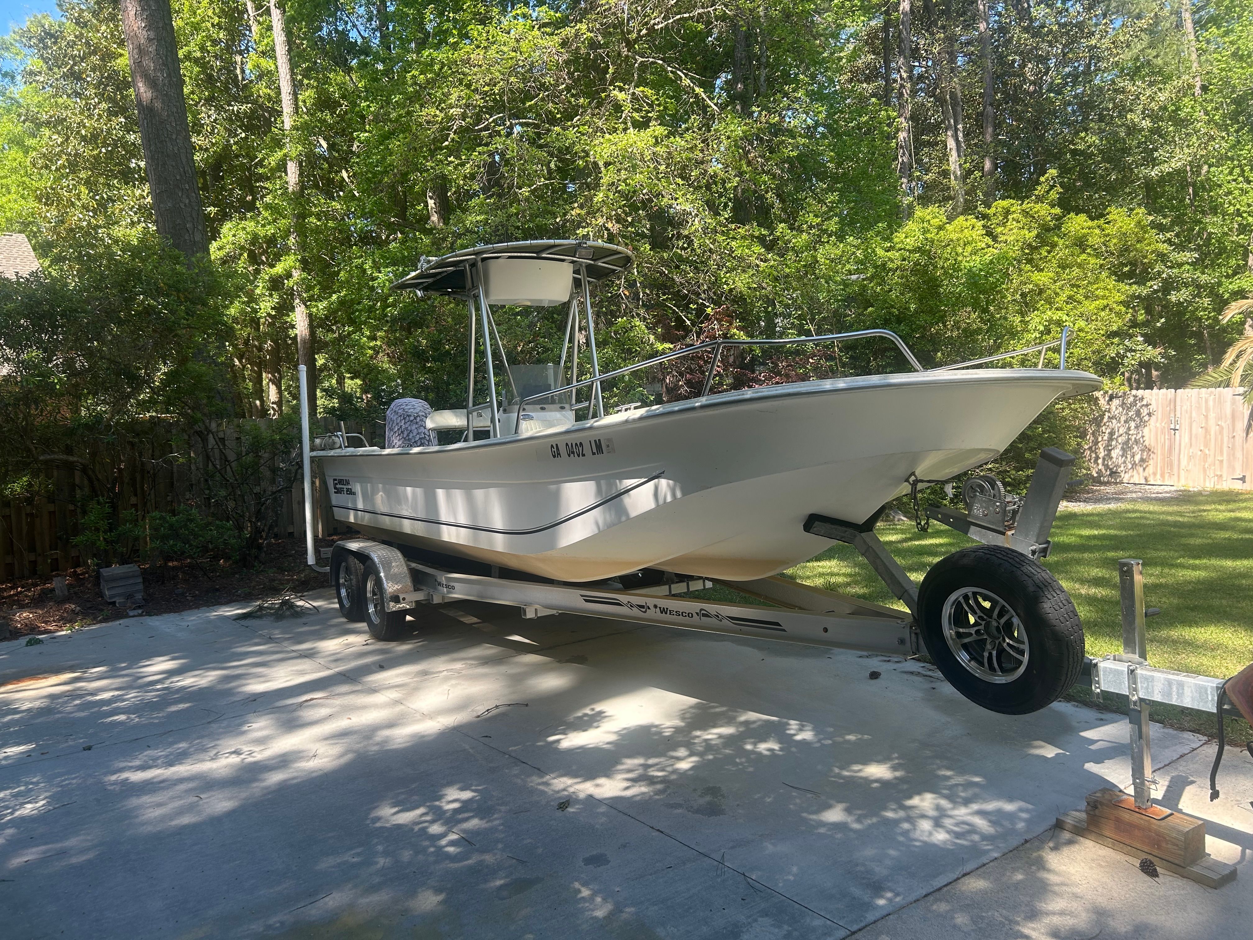 2011 Carolina Skiff 258 DLV on trailer in backyard.
