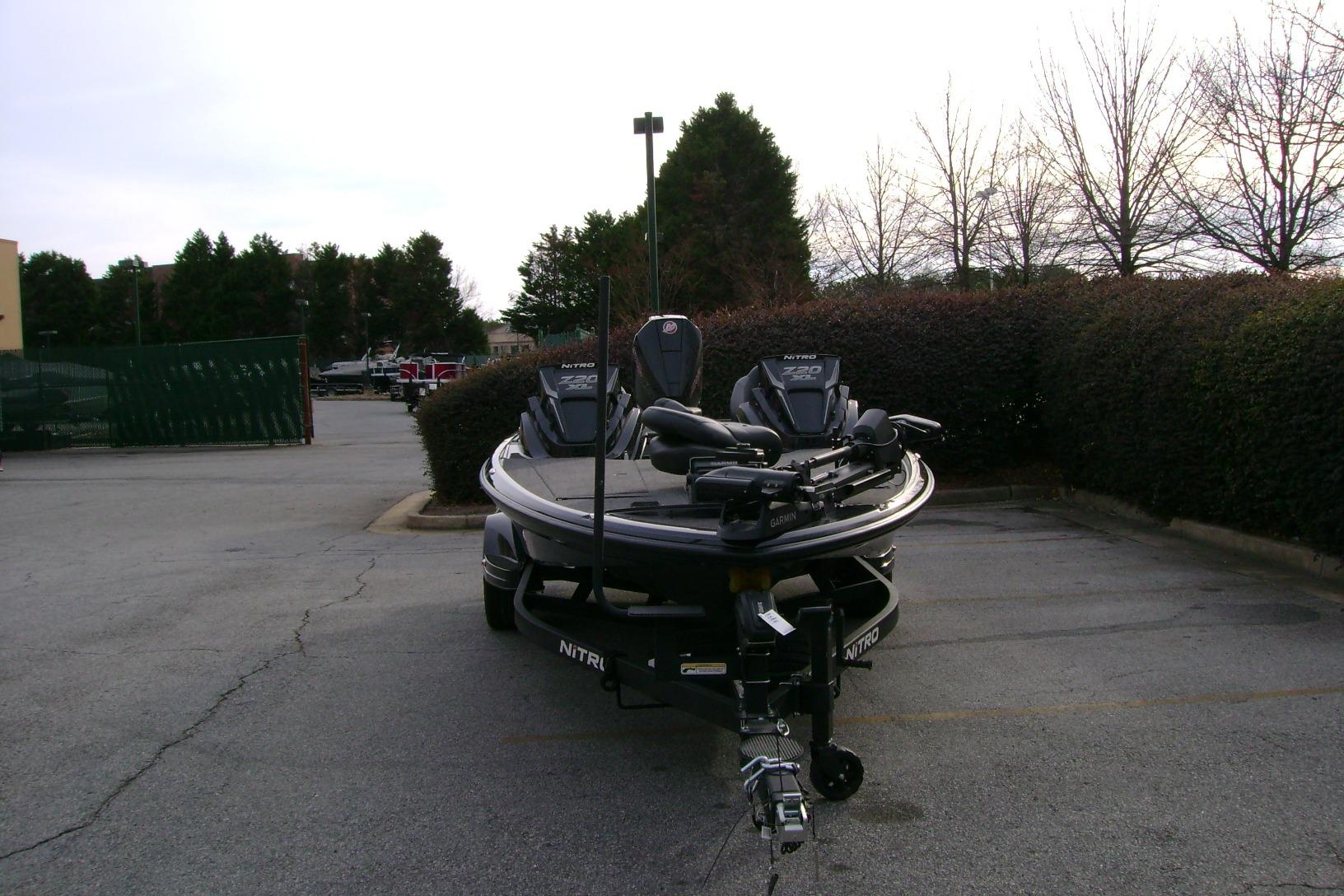 2026 Nitro Z20 XL Pro boat parked in a lot, surrounded by trees.