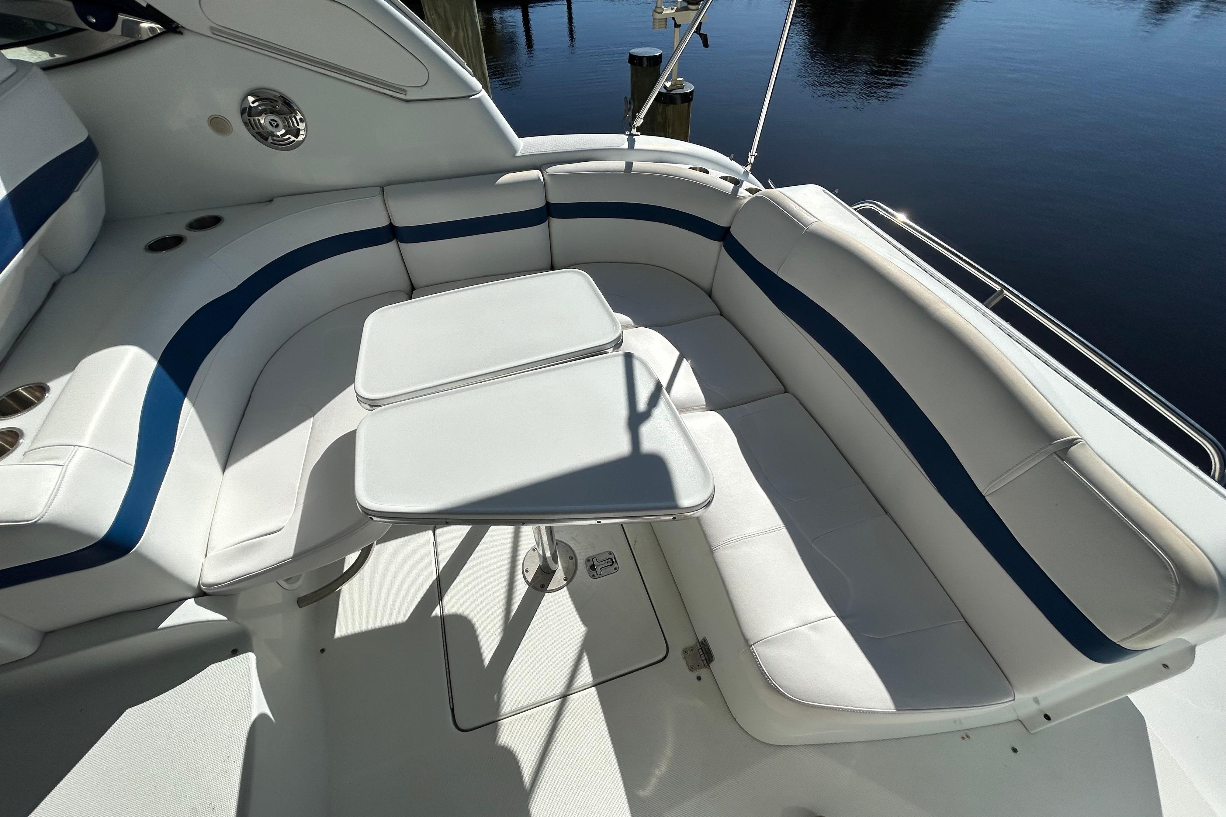 2008 Formula 34 Performance Cruiser interior with white and blue seating, dual tables, and water view.