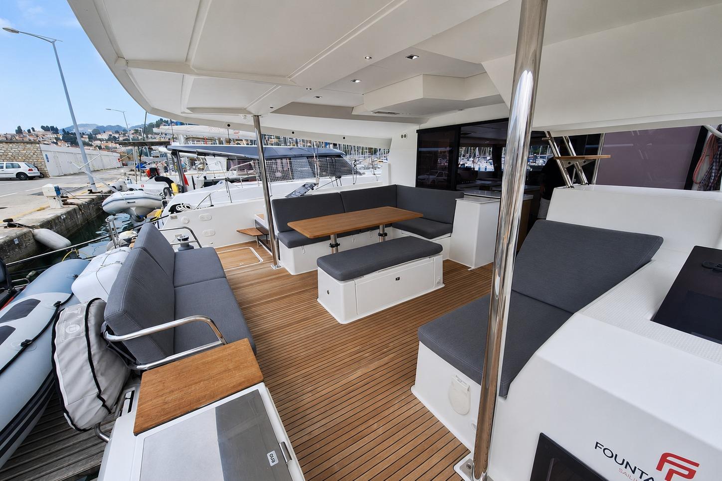 Spacious deck of 2021 Fountaine Pajot Saona 47 catamaran with comfortable seating and wooden flooring.