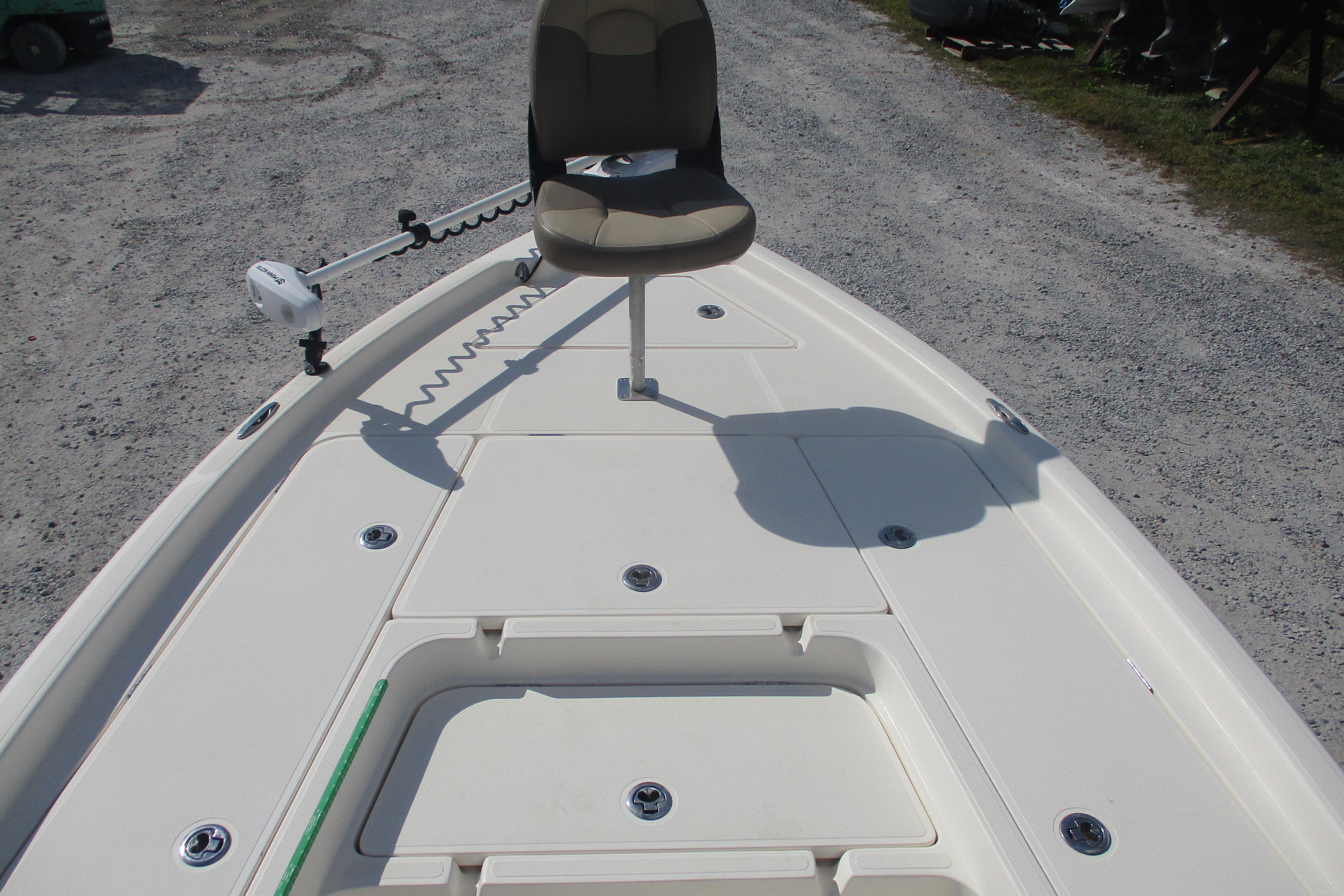 2014 Skeeter SX240 boat deck with seat and trolling motor on gravel surface.