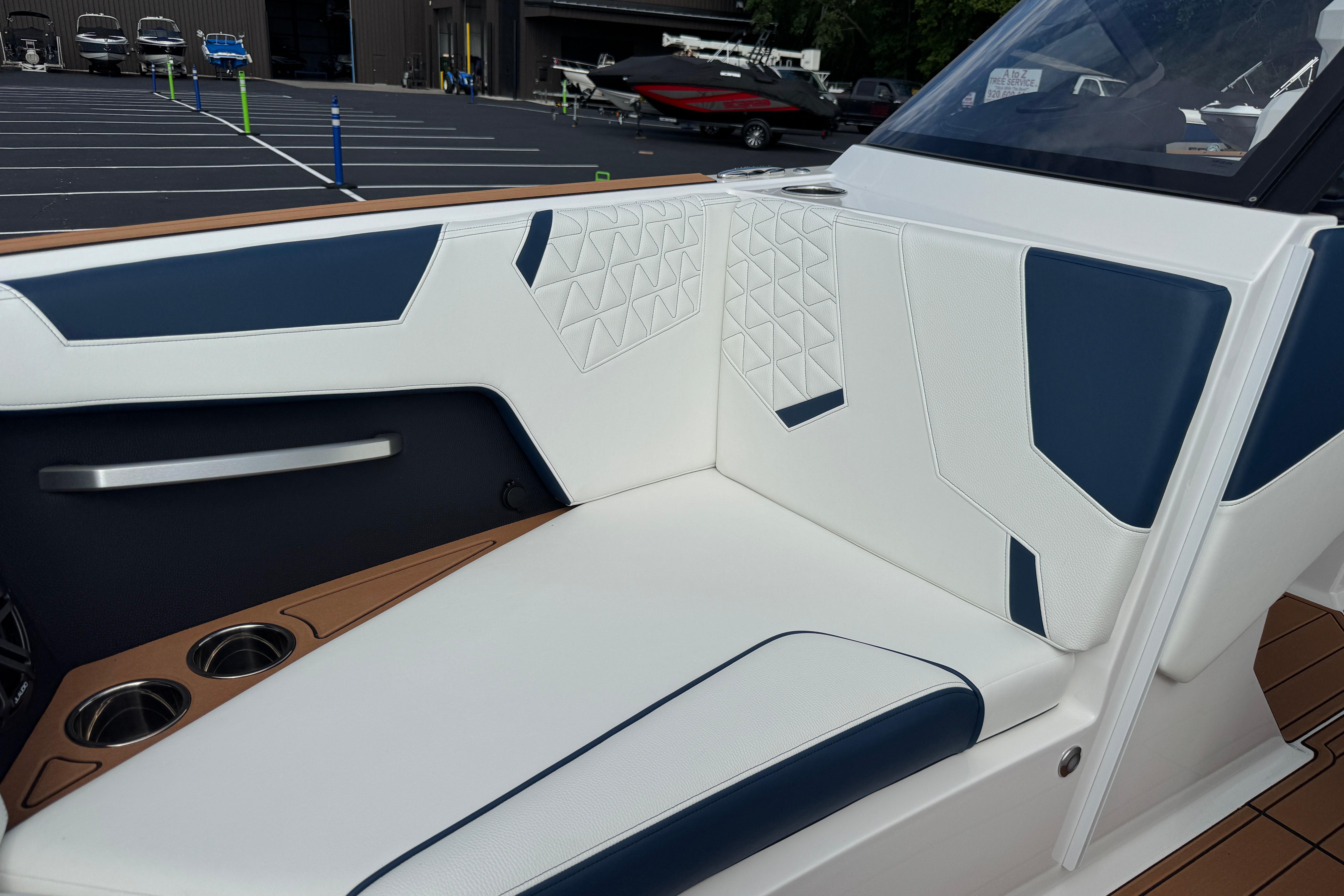 2026 Nautique Super Air Nautique GS22 interior with white and blue seating, cup holders.