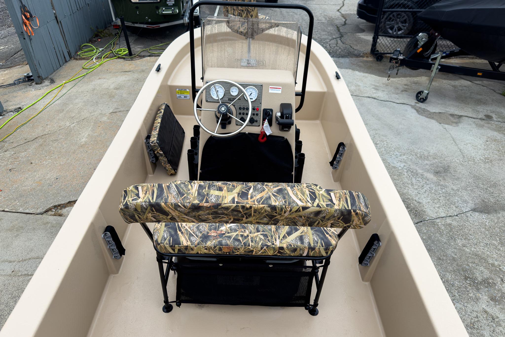 2026 Carolina Skiff E18 JVX CC Sportsman boat interior with camouflage seating and steering console.