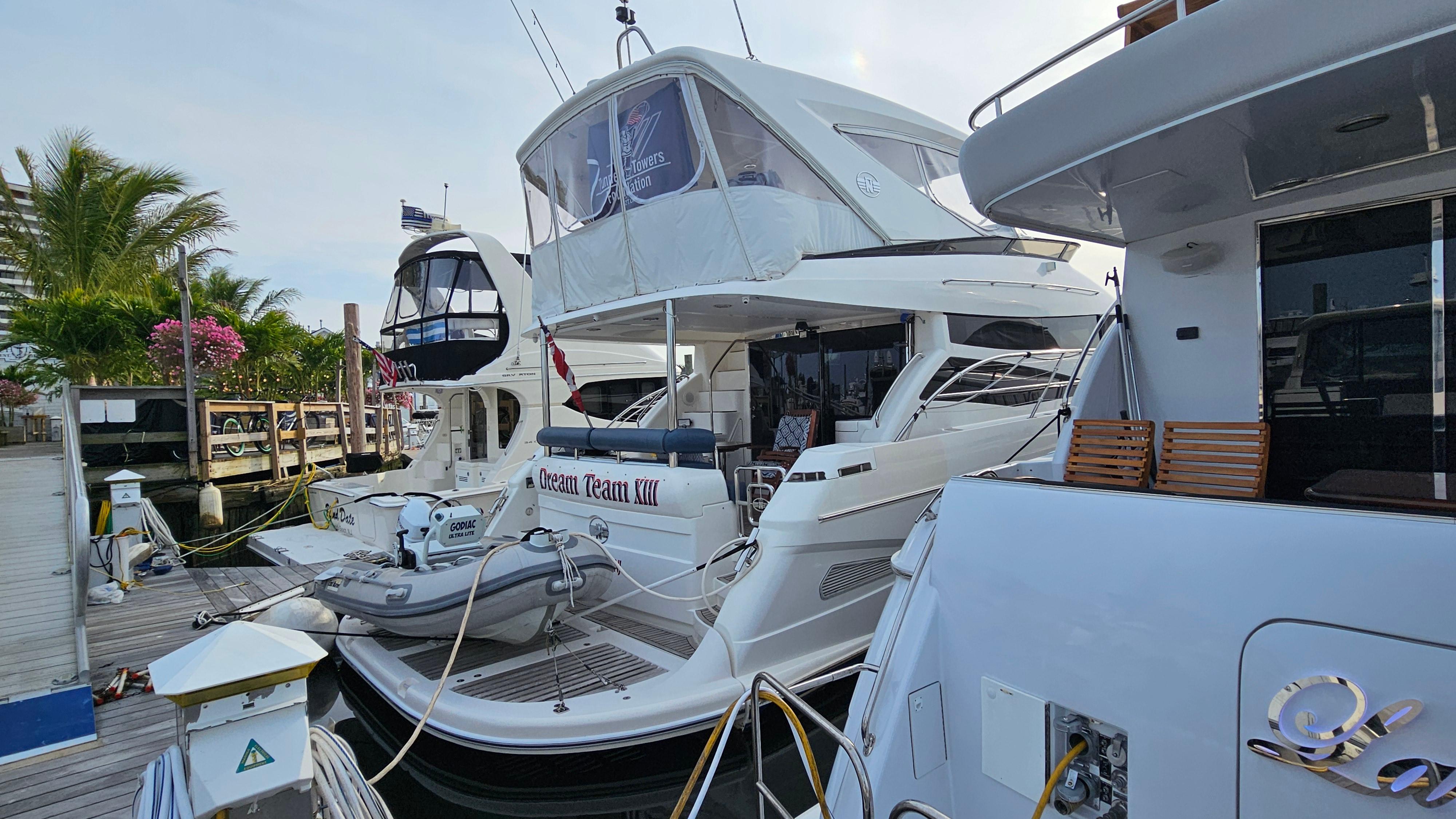 2005 Neptunus 56 Flybridge yacht docked at marina with palm trees.