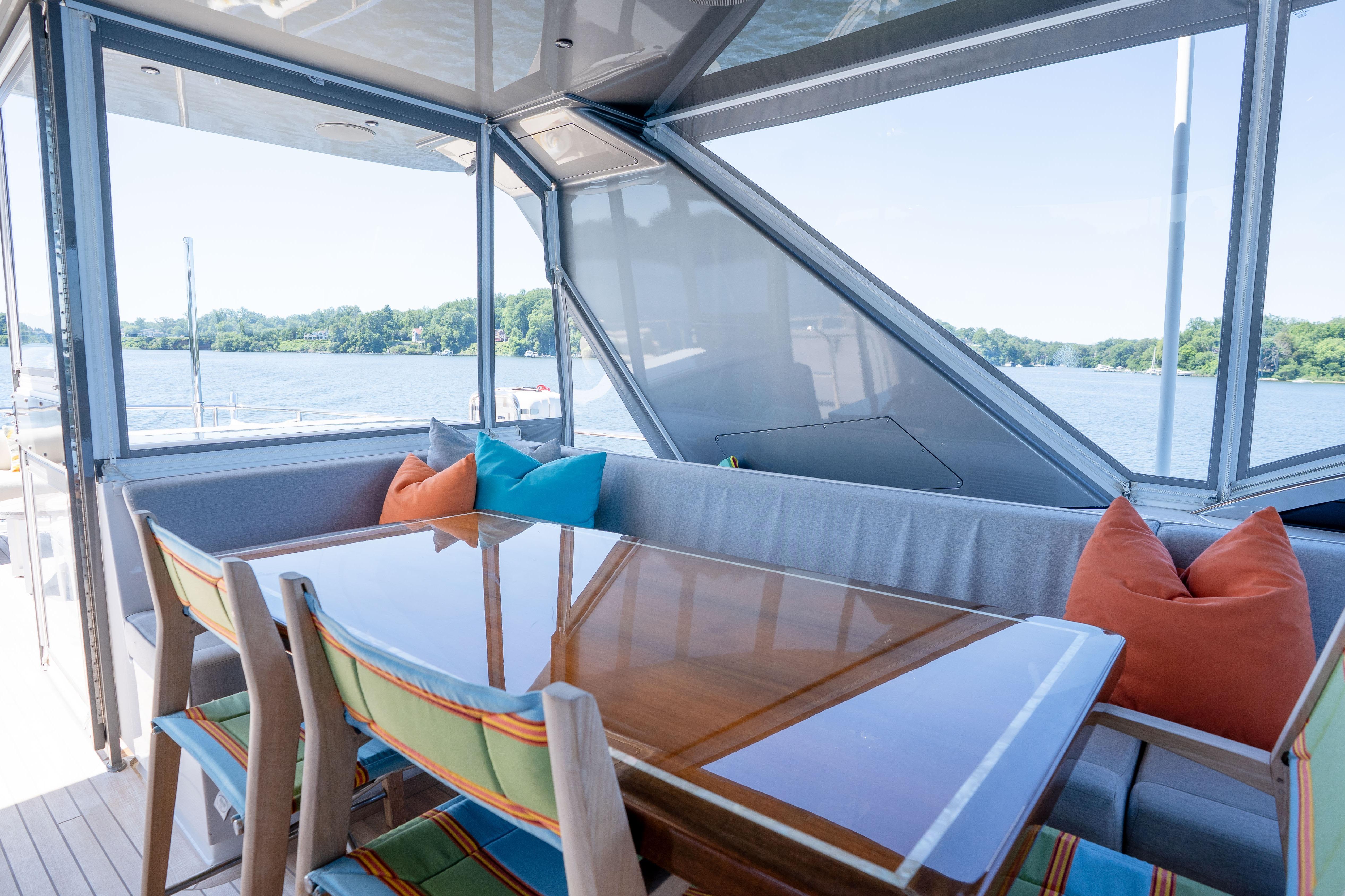Luxurious 2021 Hatteras M75 Panacera yacht interior with dining area and scenic water view.