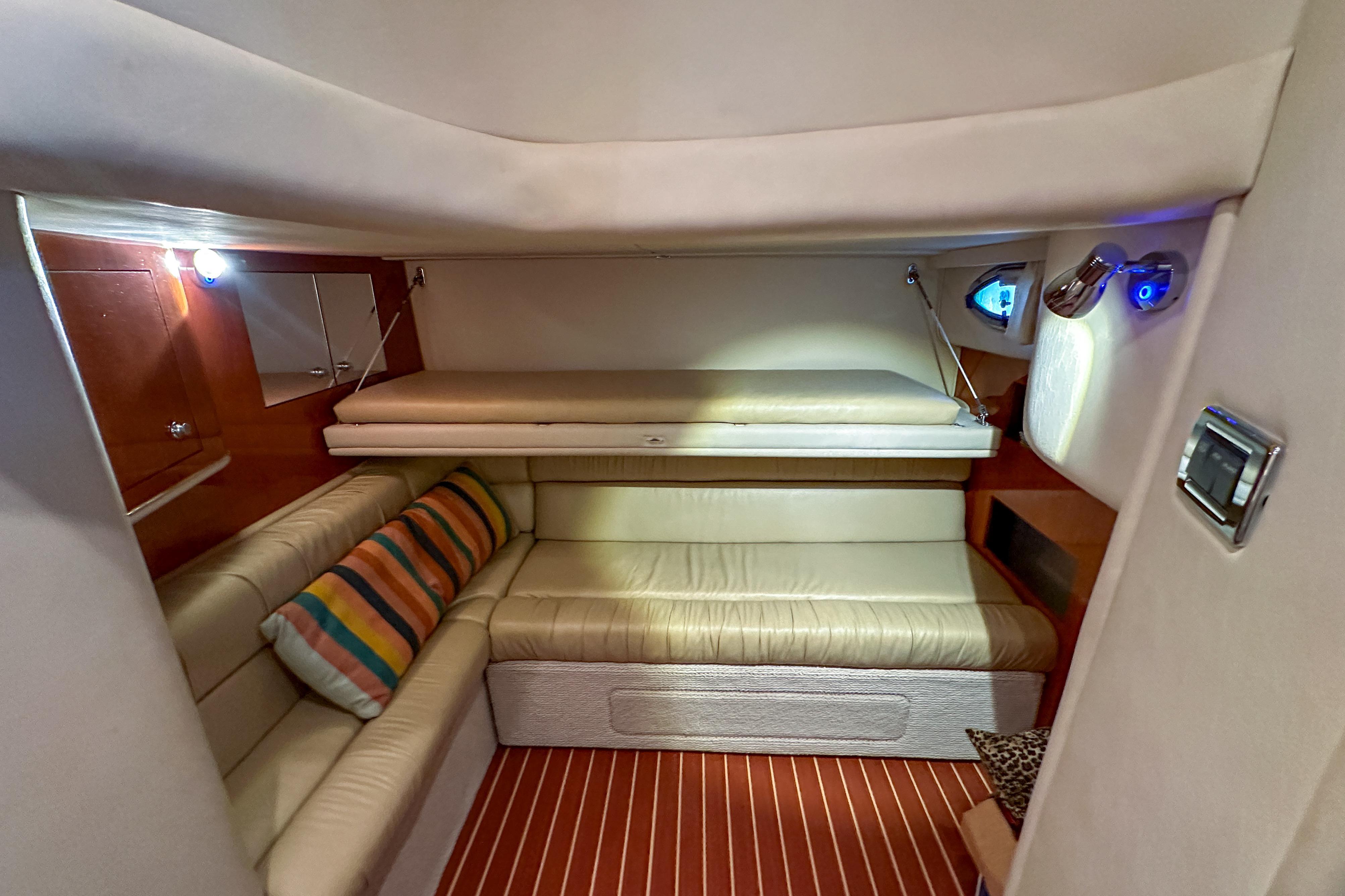 Interior of 2001 Sea Ray 410 Sundancer yacht with cozy seating and striped cushions.