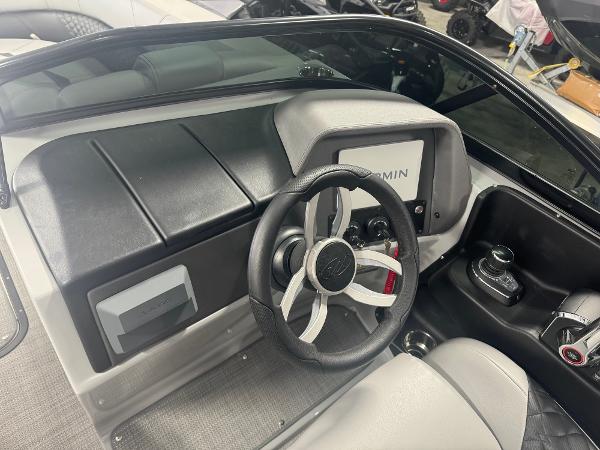2025 Manitou LX boat dashboard with steering wheel and Garmin display.
