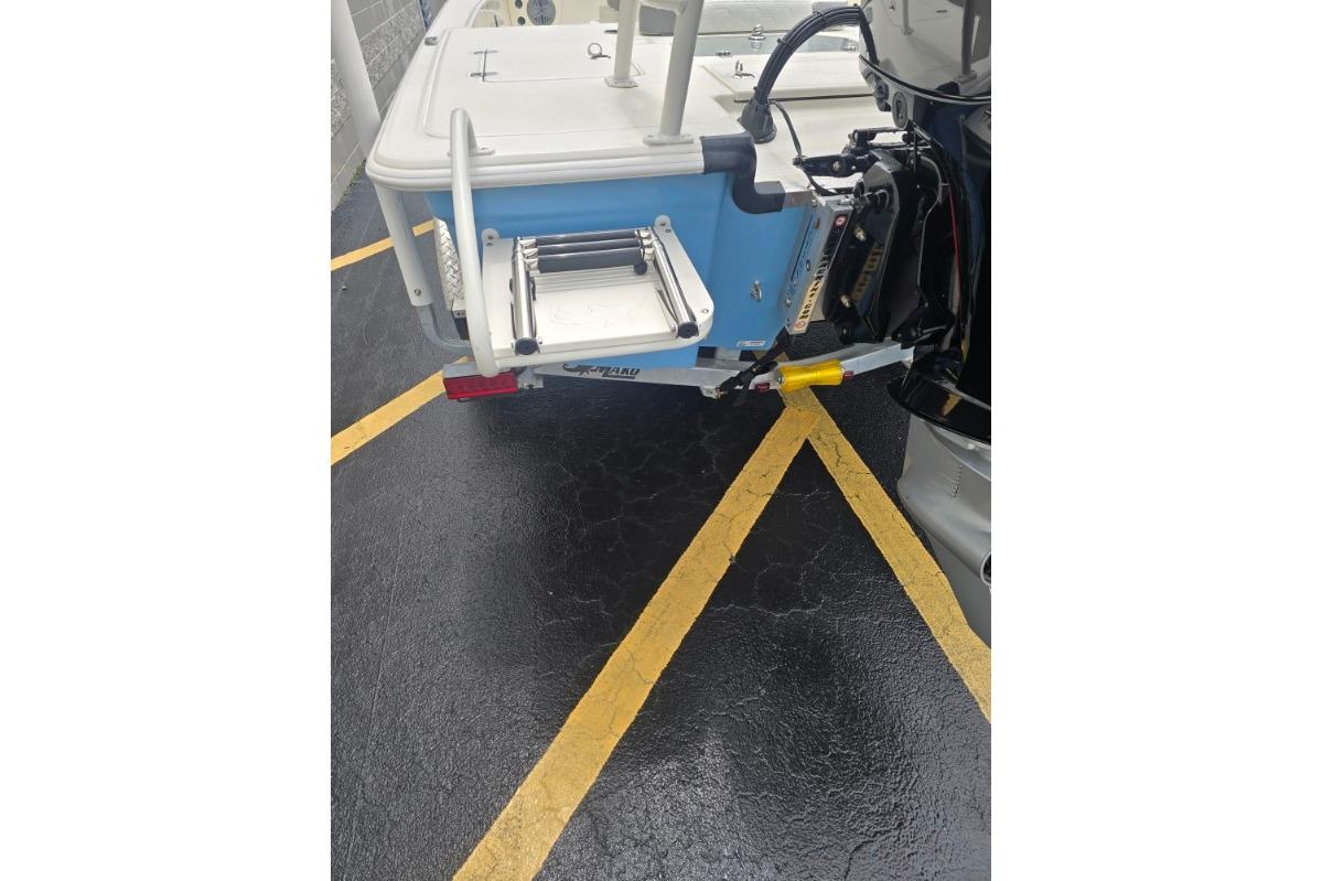 2026 Mako 18 Pro Skiff boat rear view with motor and ladder.
