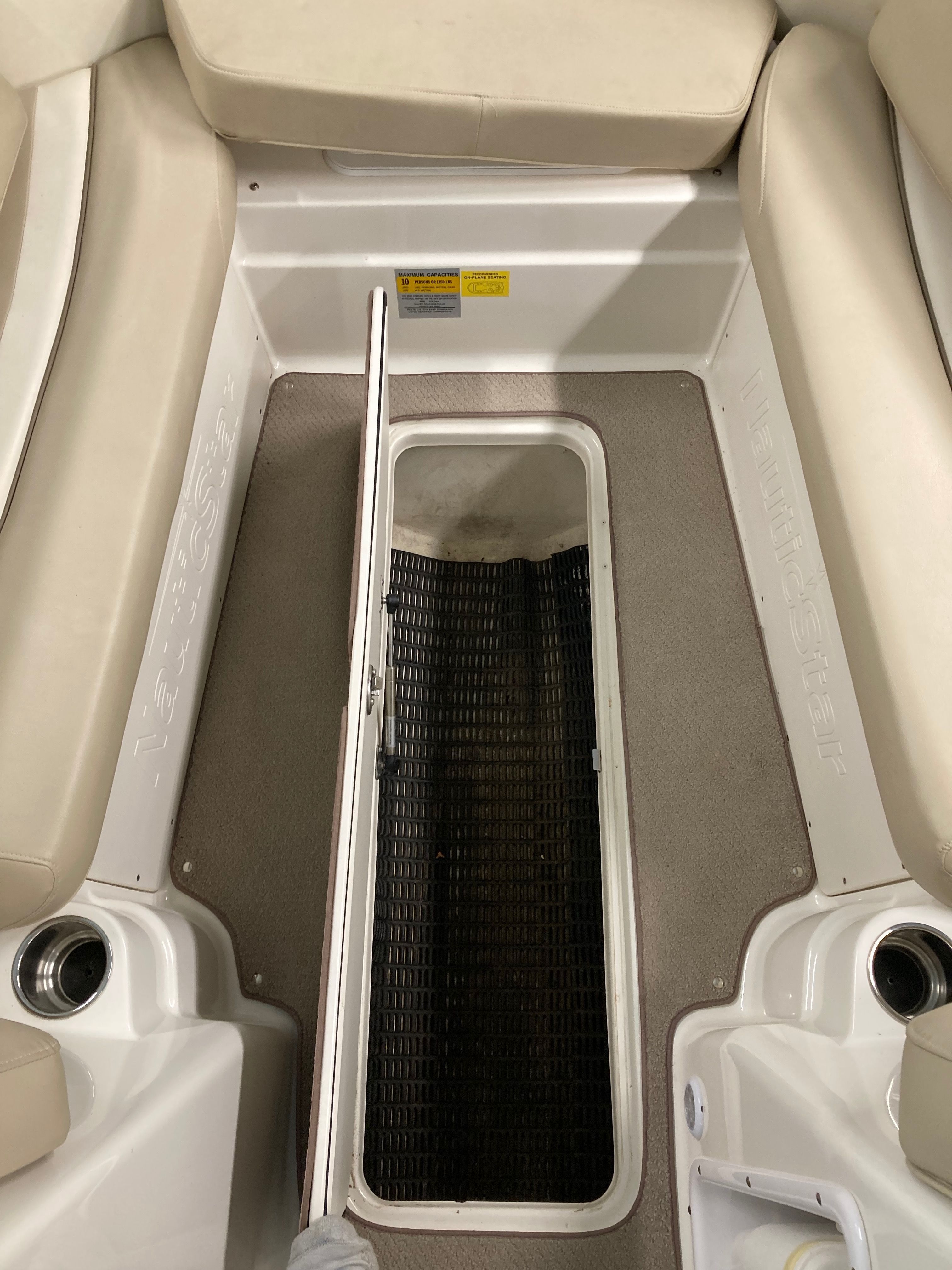 Interior of a 2016 Custom 223 DC boat with floor storage compartment.