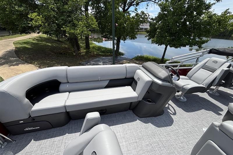 2026 Sun Tracker SportFish 20 DLX pontoon boat with spacious seating by a serene lake.