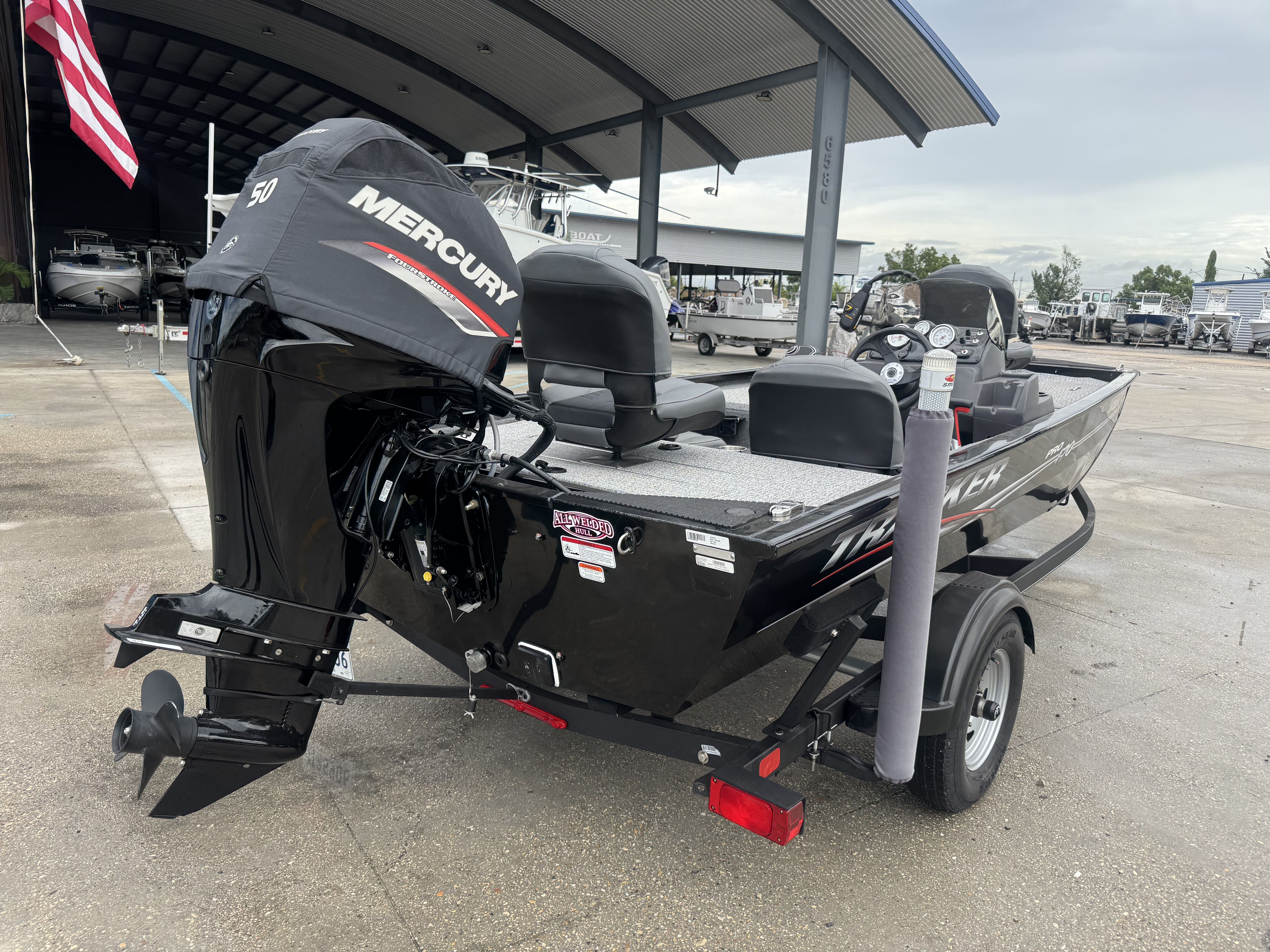 2024 Tracker Pro 170 boat with Mercury engine, parked under a covered area.
