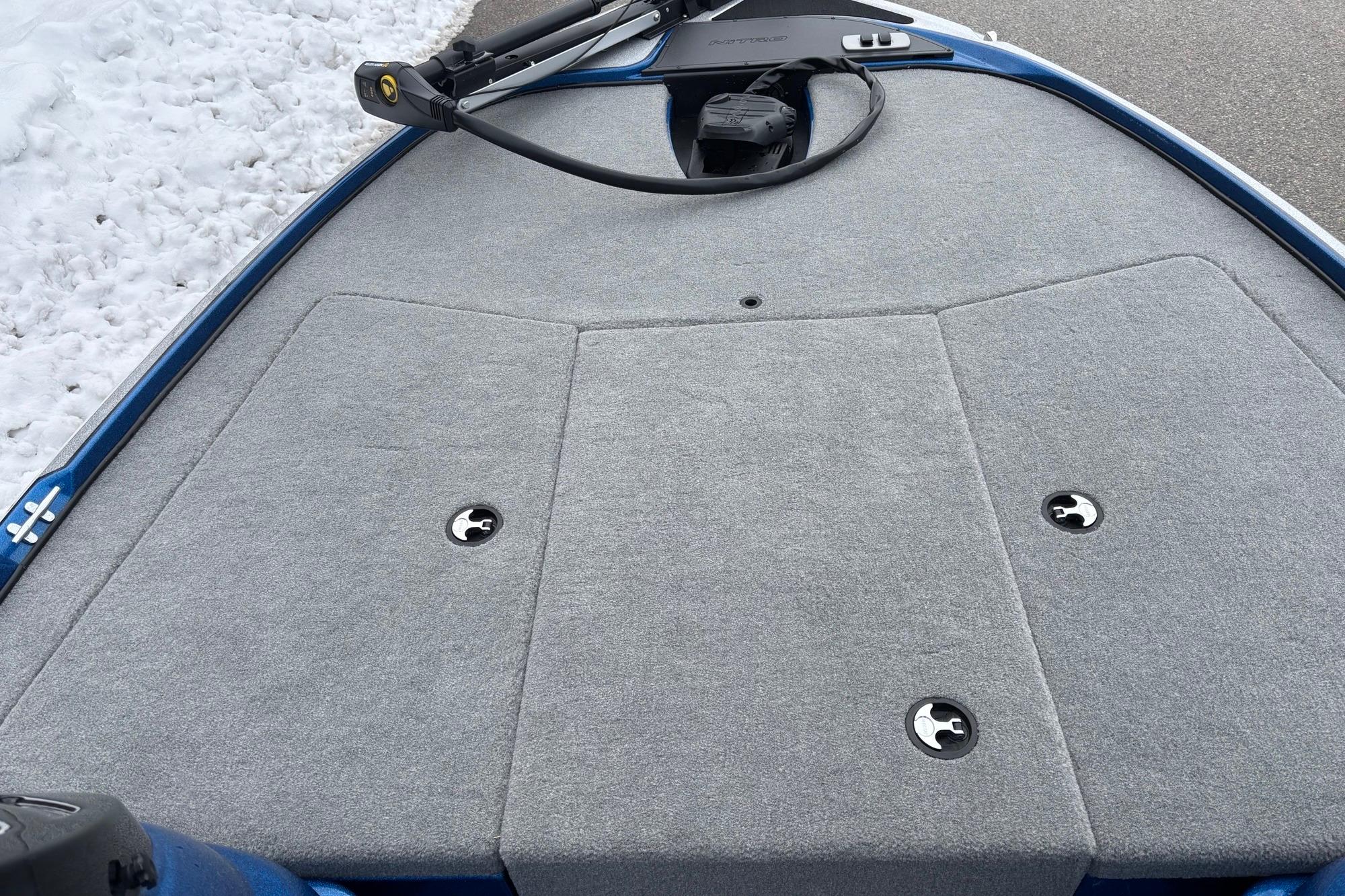Front deck of 2026 Nitro Z17 boat with gray carpet and snow in background.
