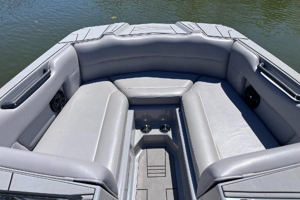 2024 Moomba Max boat interior with gray seating and cup holders on a calm lake.