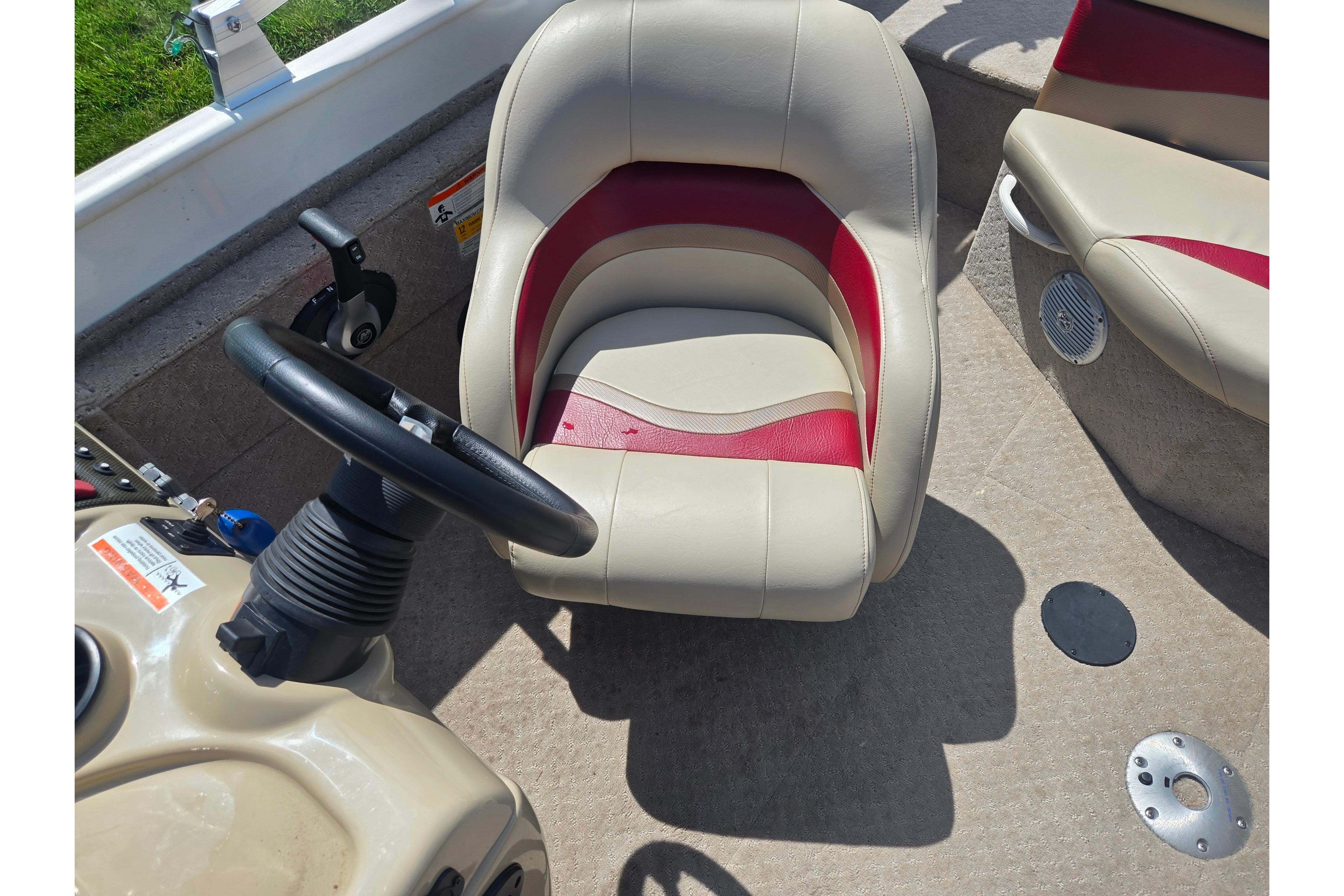 2015 Lowe Sport Deck 224 boat interior with steering wheel and beige-red seating.