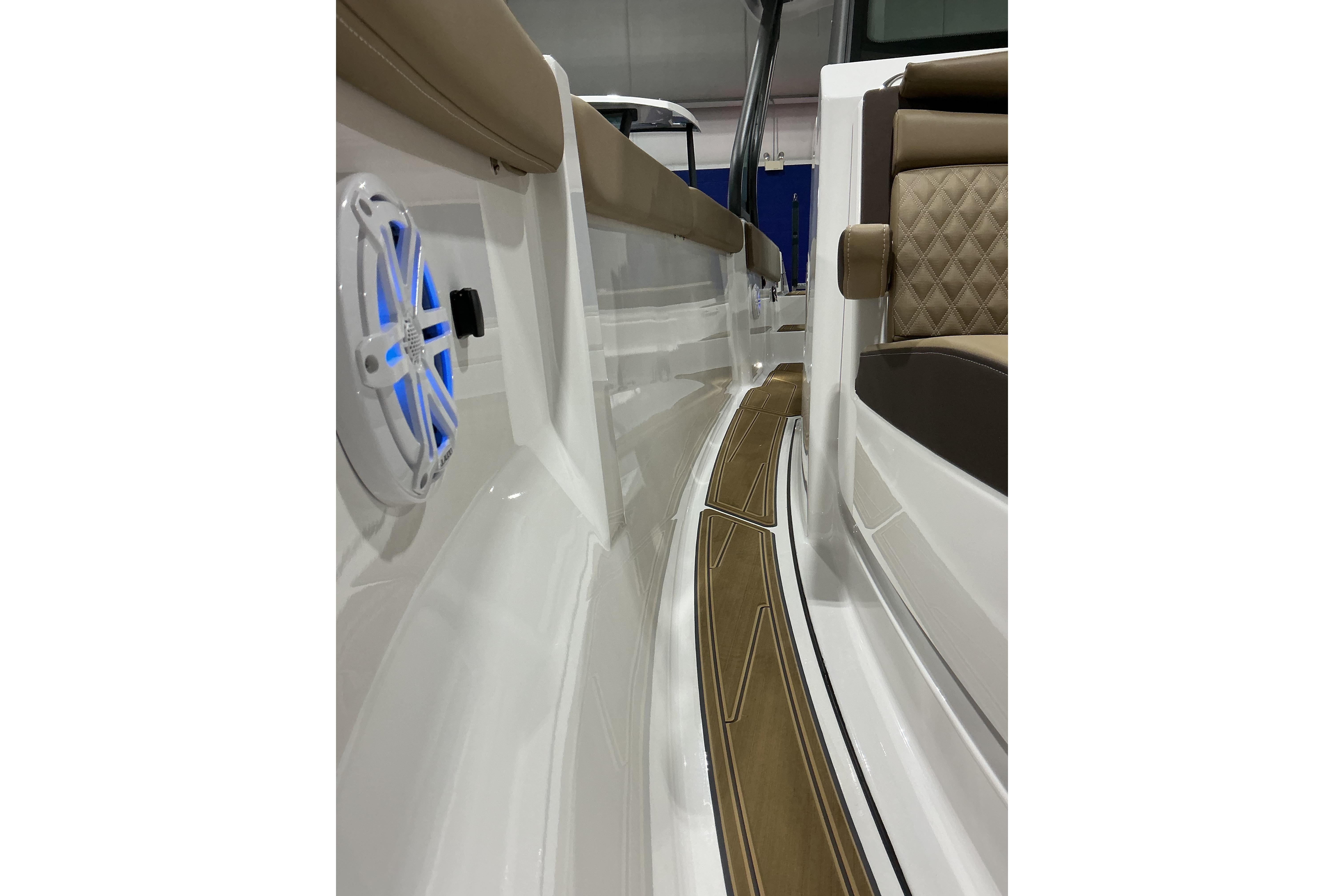 2026 Monterey Elite 25 SD boat interior with cushioned seating and blue-lit speaker.