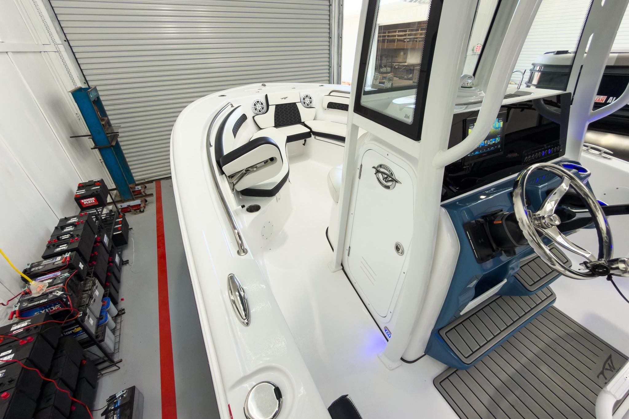 The image shows the cockpit of a 2026 Tidewater 220 LXF boat in a warehouse.