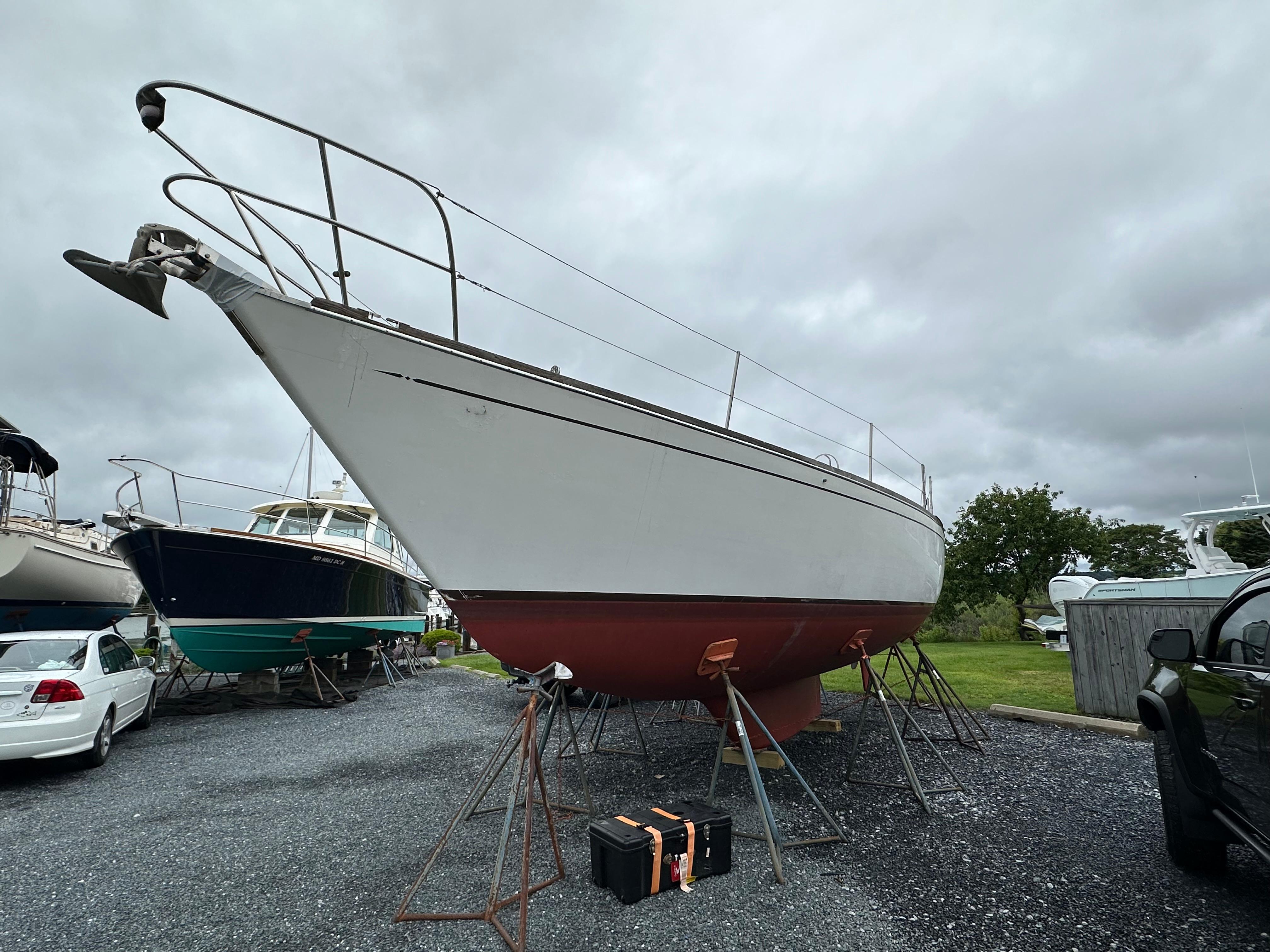 1981 Tartan 37 sloop on stands, overcast sky, boatyard setting.