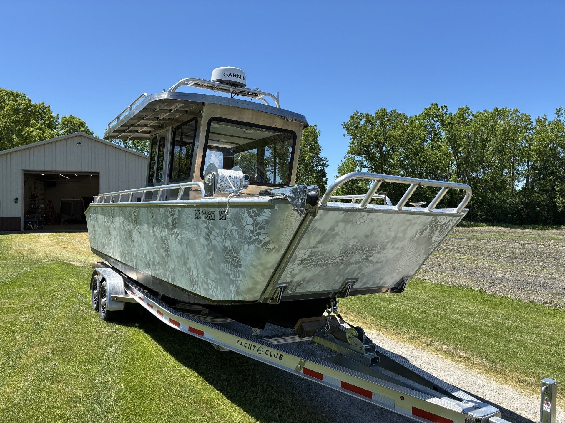 Custom Landing Craft 2026 on trailer, parked in front of a garage.