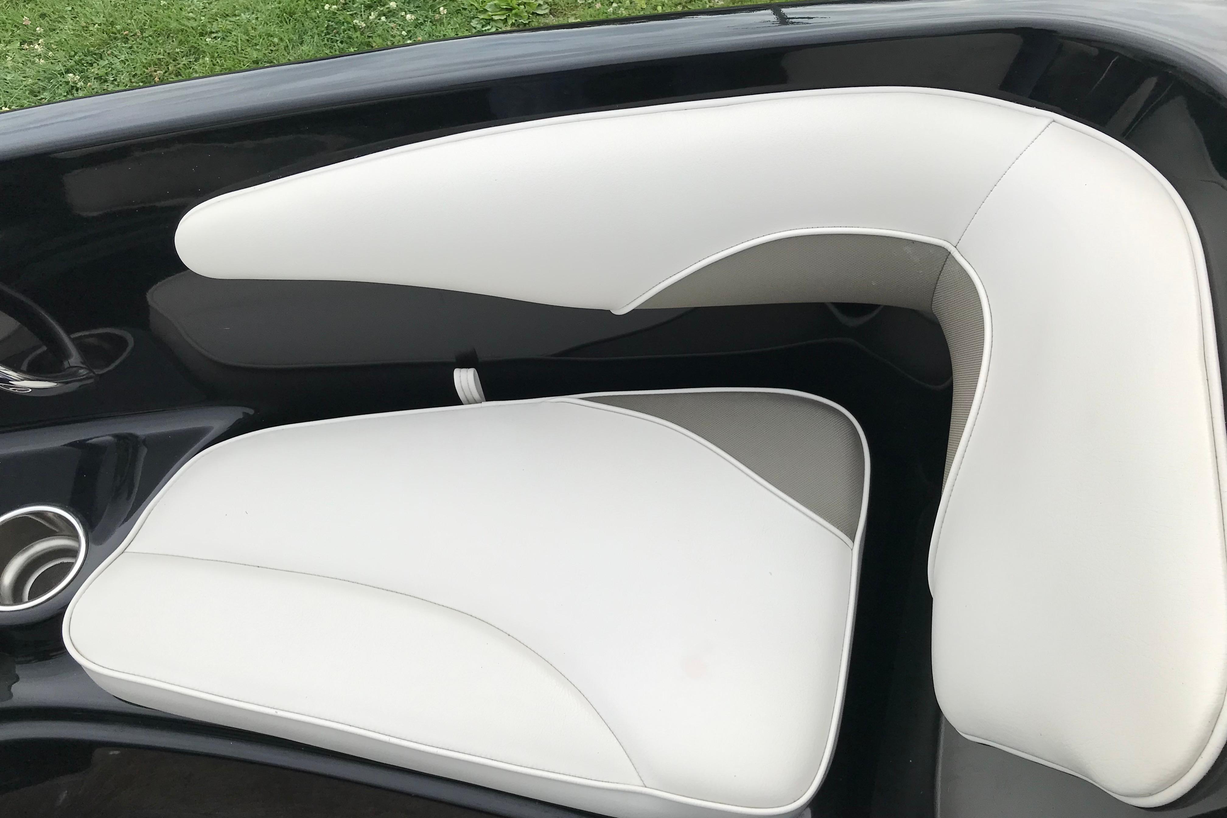 2015 Crownline 18 SS boat interior with white cushioned seating and cup holder.