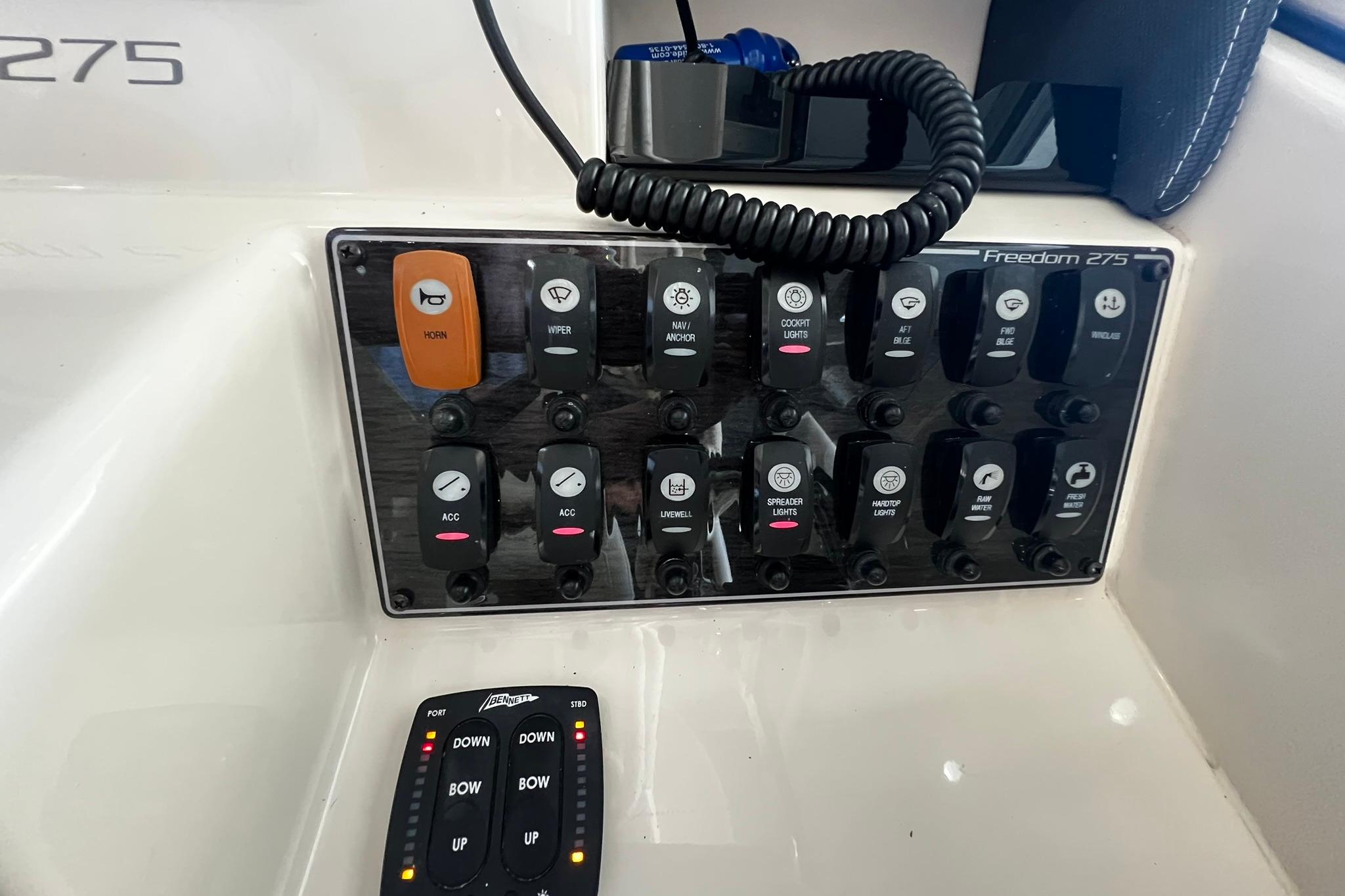 Control panel of a 2014 Grady-White Freedom 275 boat with various switches and buttons.