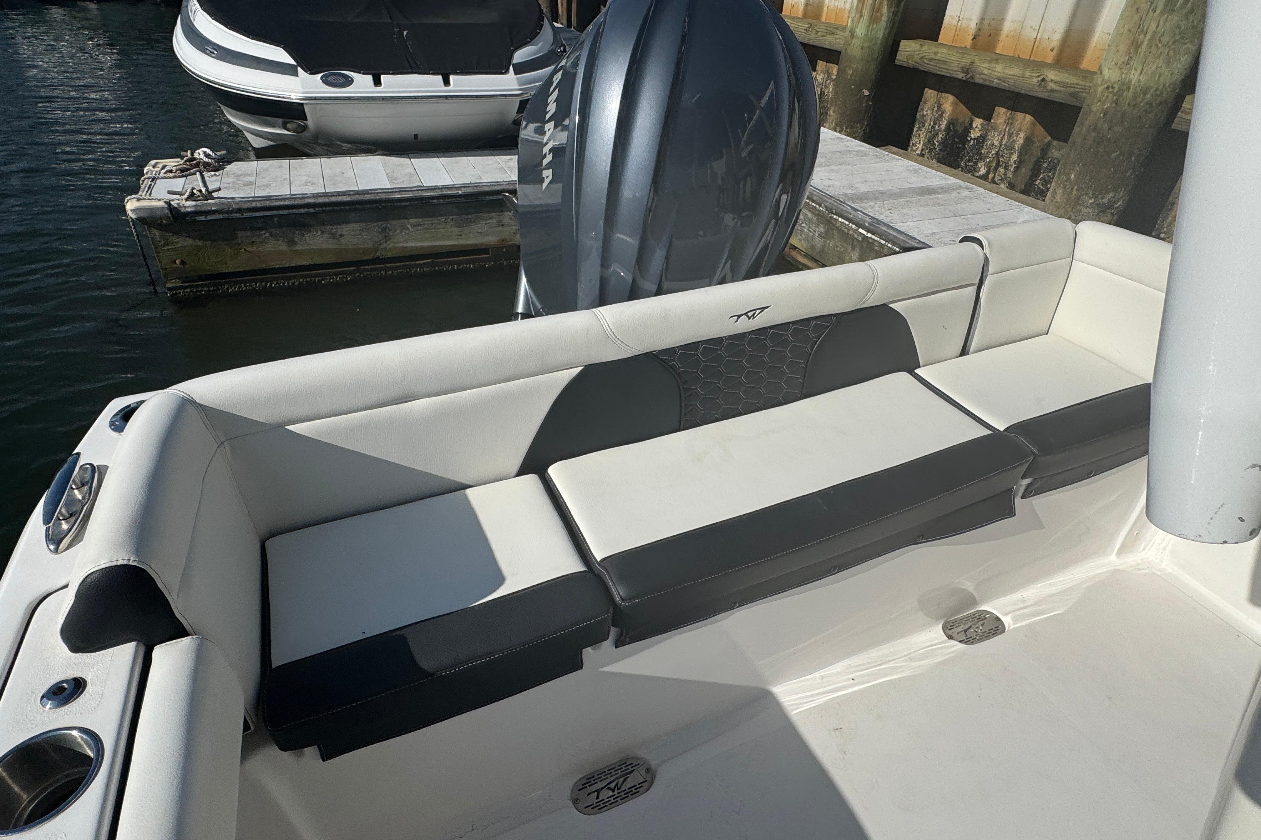 2025 Tidewater 232 LXF boat interior with cushioned seating and outboard motor.