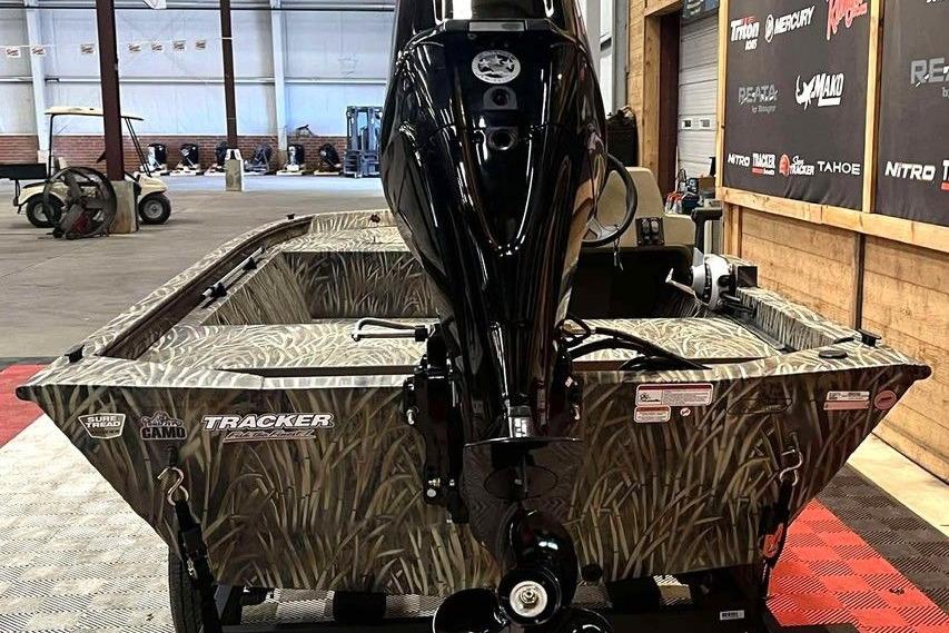 2026 Tracker Grizzly 1648 SC boat with camo design in a showroom setting.