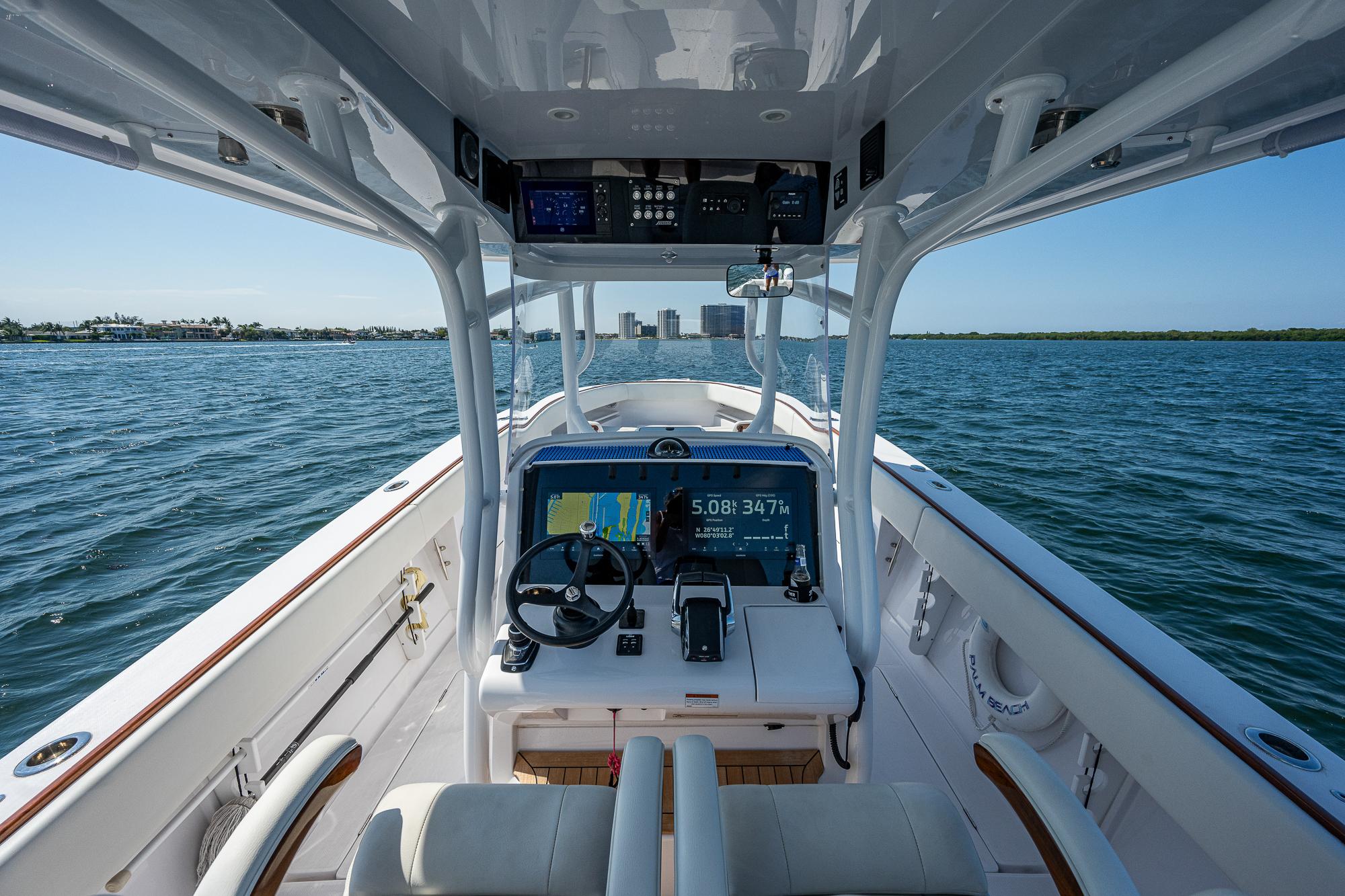 2023 Jupiter 38 boat interior with navigation system, steering wheel, and ocean view.