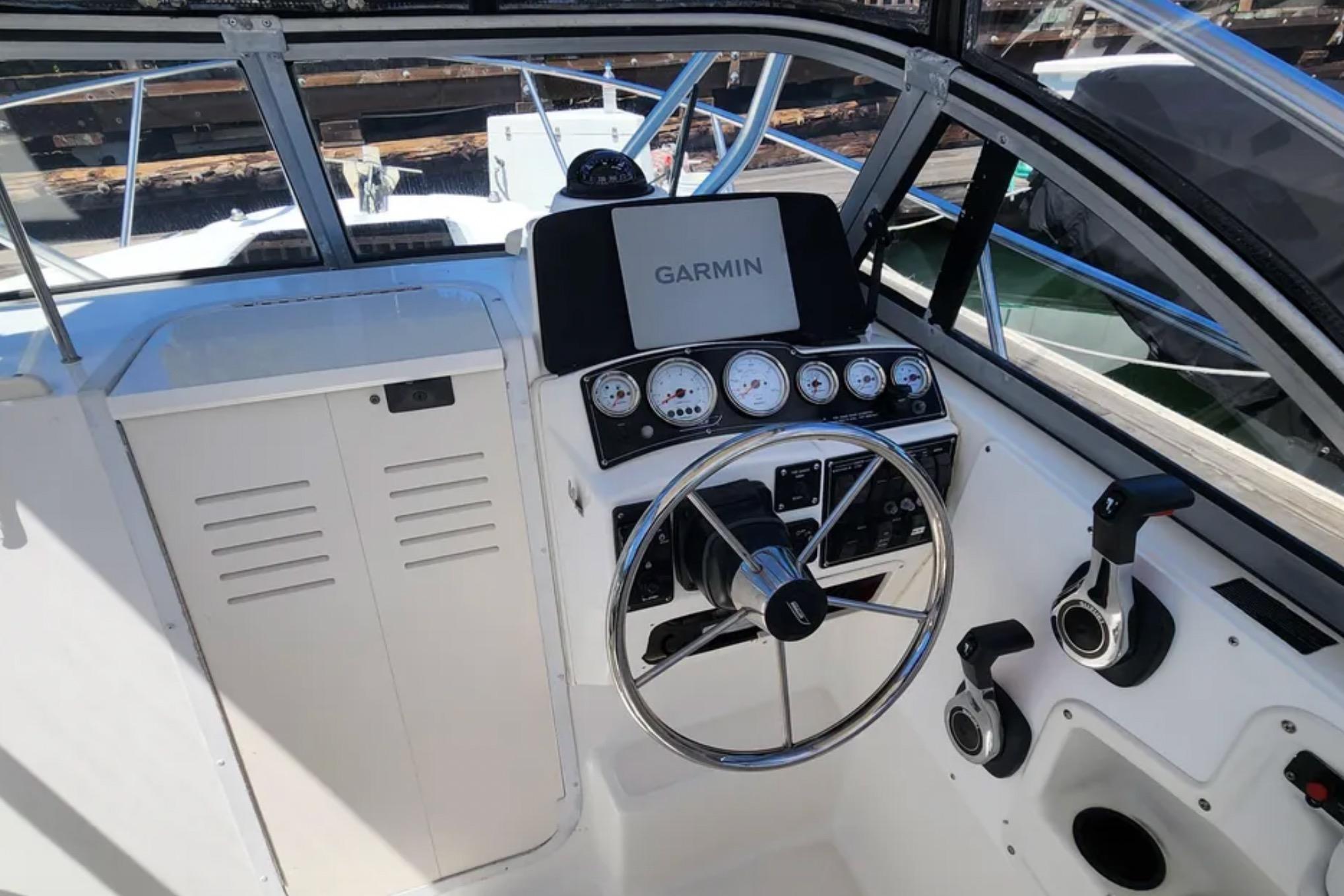 Cockpit of 2000 Boston Whaler 21 Conquest with Garmin navigation system and steering wheel.