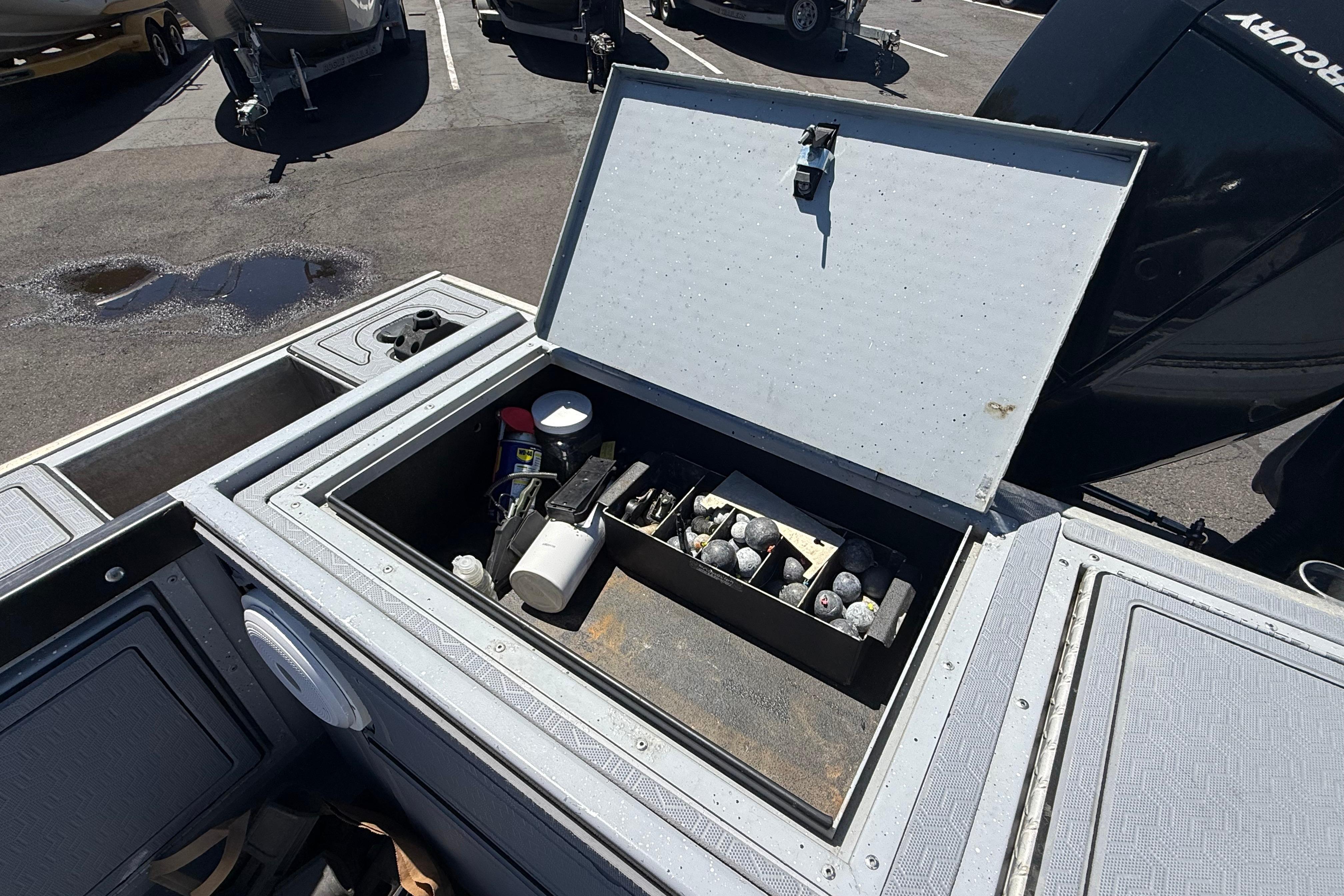 Open storage compartment on 2015 Alumaweld Pacific XD 28 boat, containing various items.