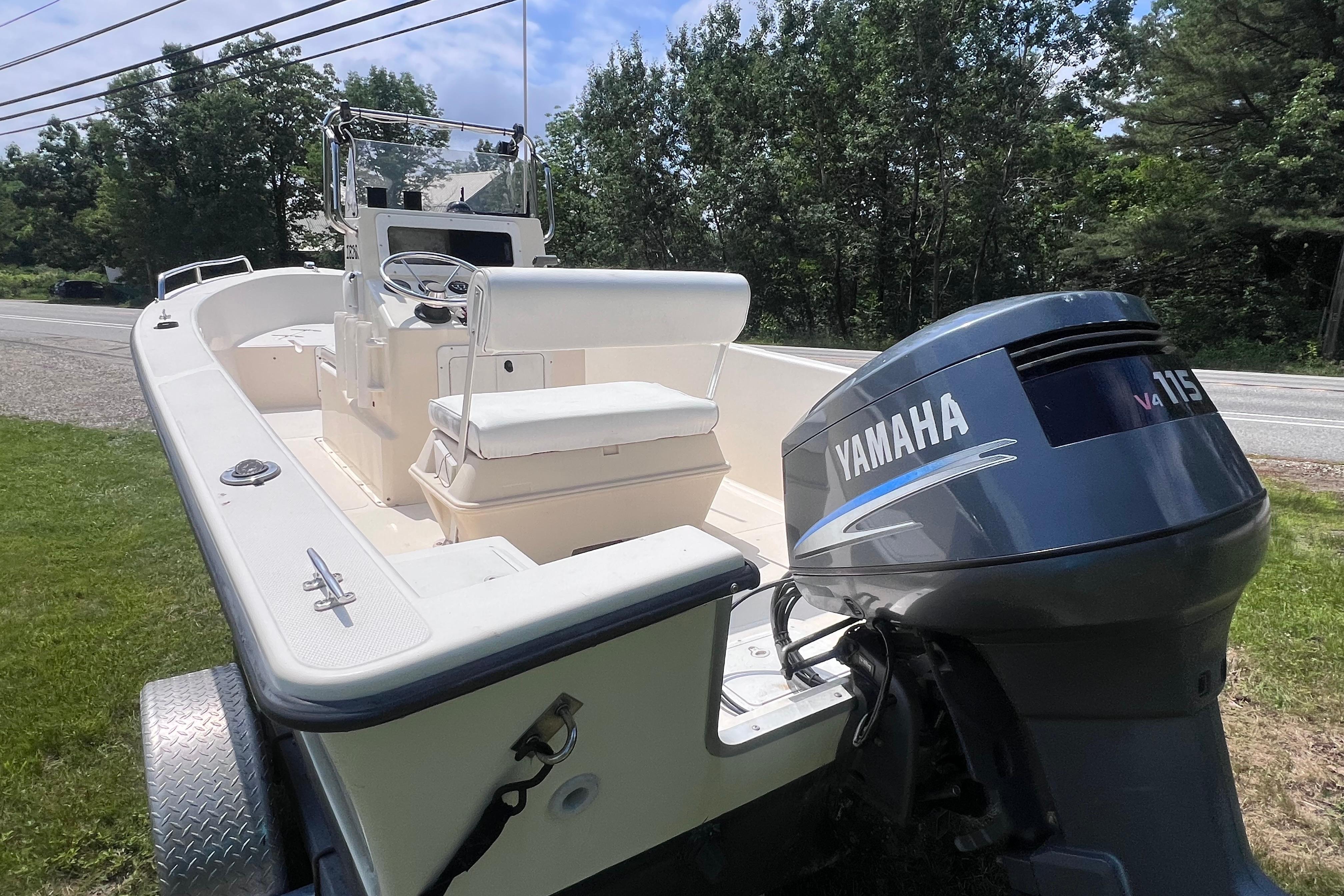 2003 May-Craft 1820CC boat with Yamaha V4 115 engine, parked on grass.