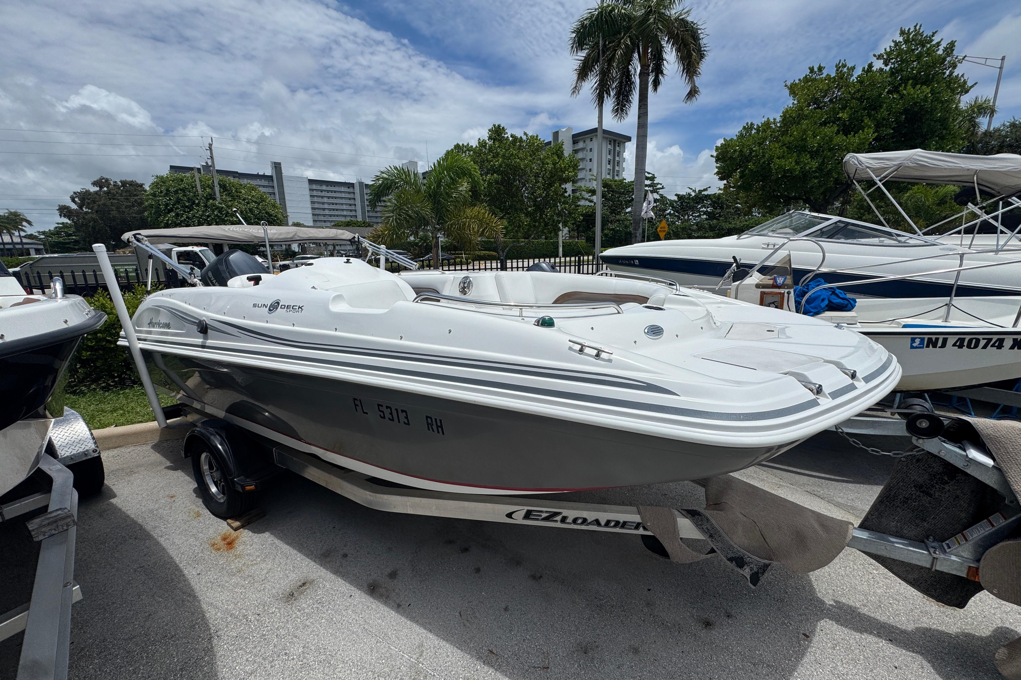 2013 Hurricane SunDeck Sport 188 OB boat on trailer, parked outdoors.