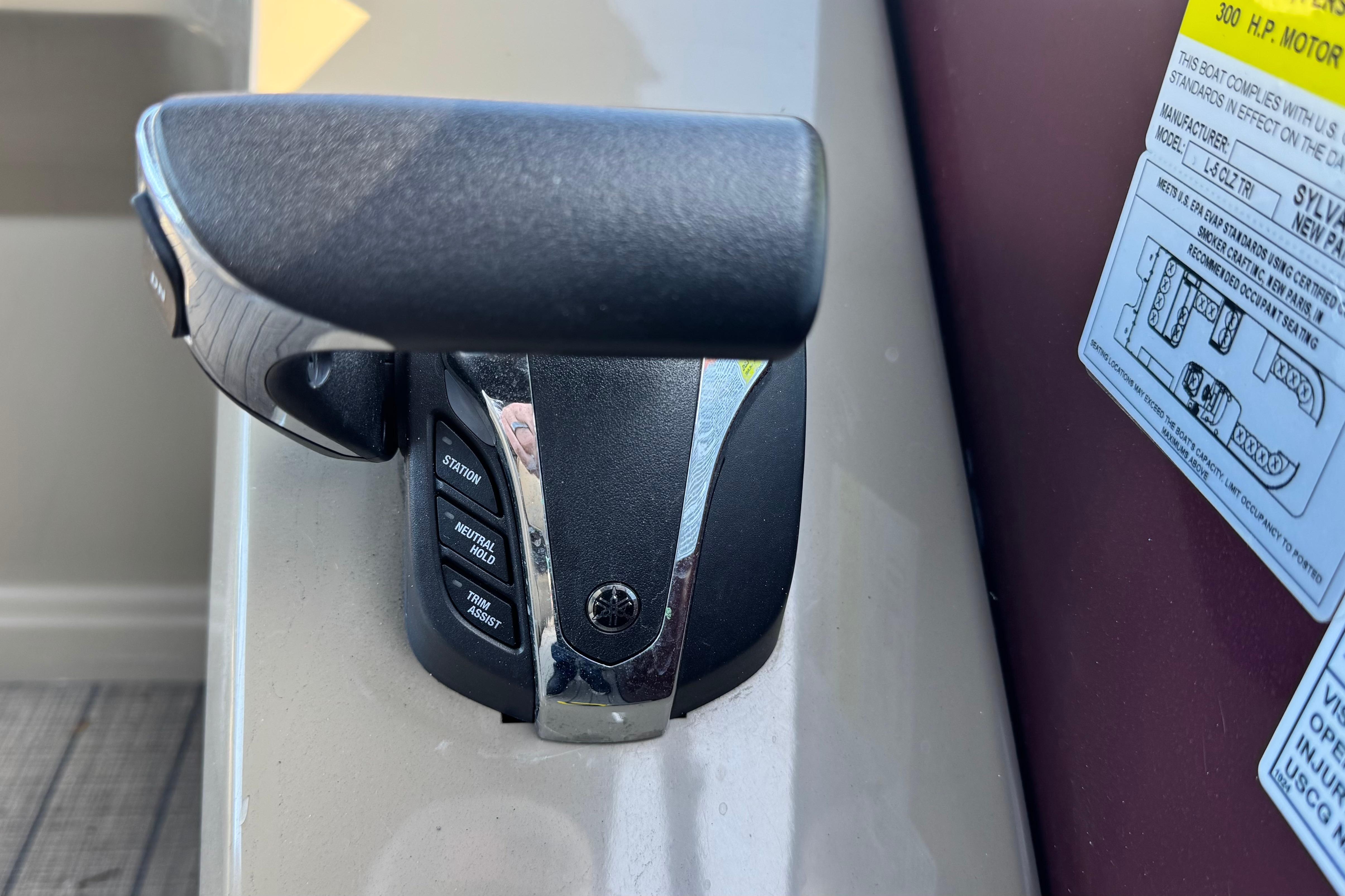 Close-up of 2023 Sylvan L5 CLZ boat throttle control with label and buttons.